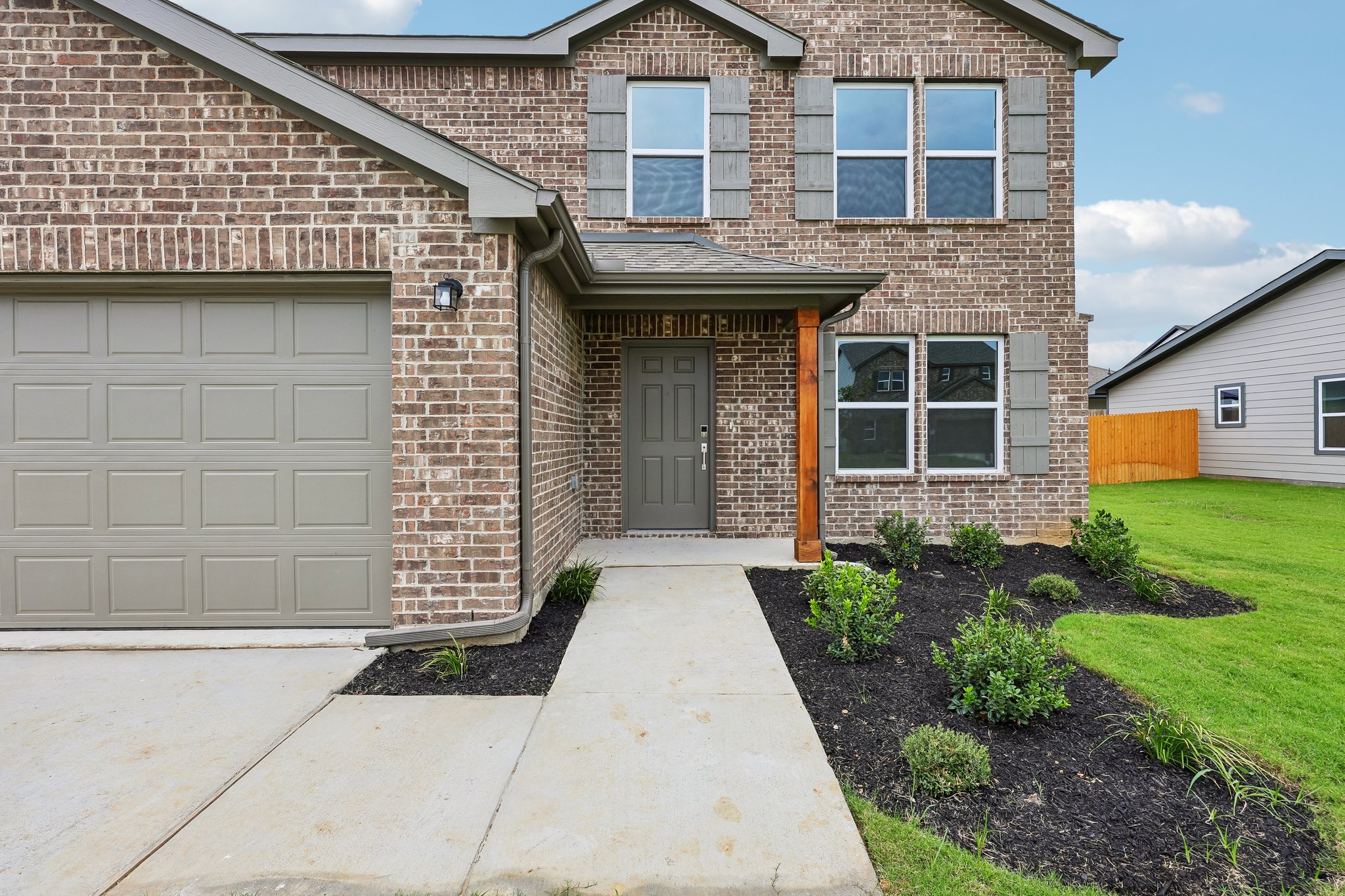A brick house with a driveway.