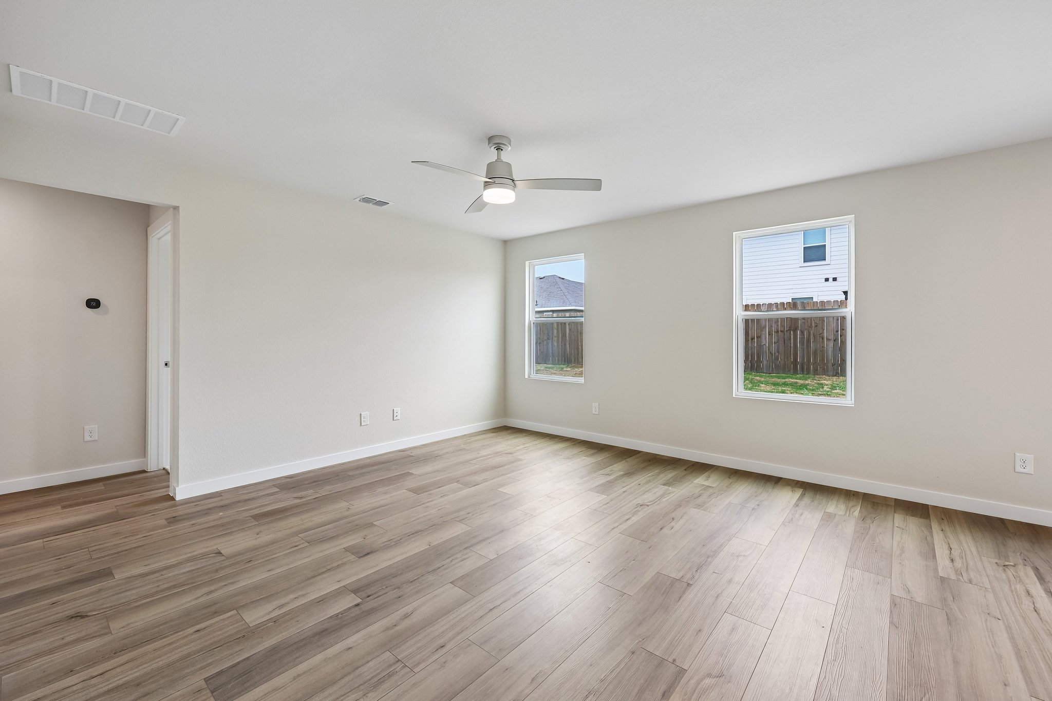A room with a wood floor and a ceiling fan.