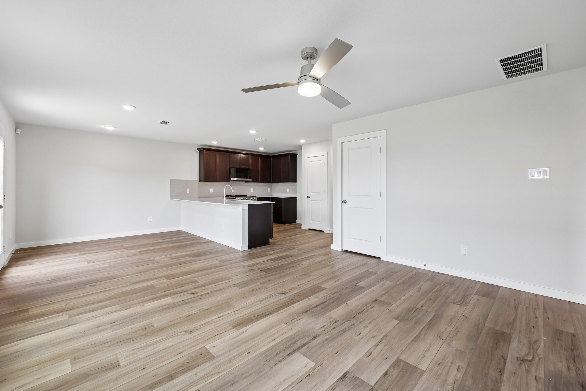 A room with a wood floor and a ceiling fan.