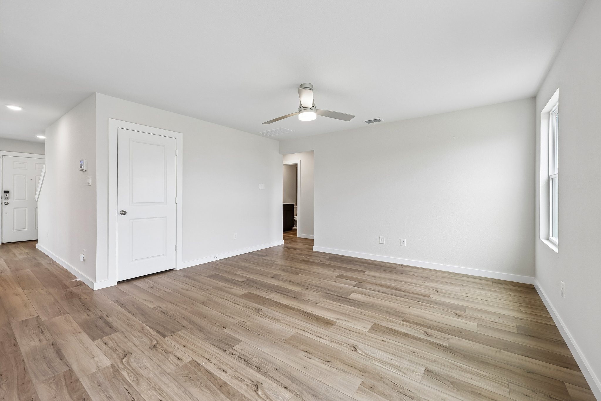 A room with white doors and a wood floor.