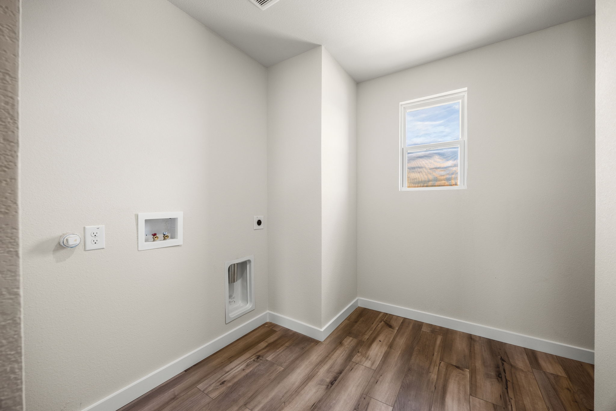 A room with a wood floor and white walls.