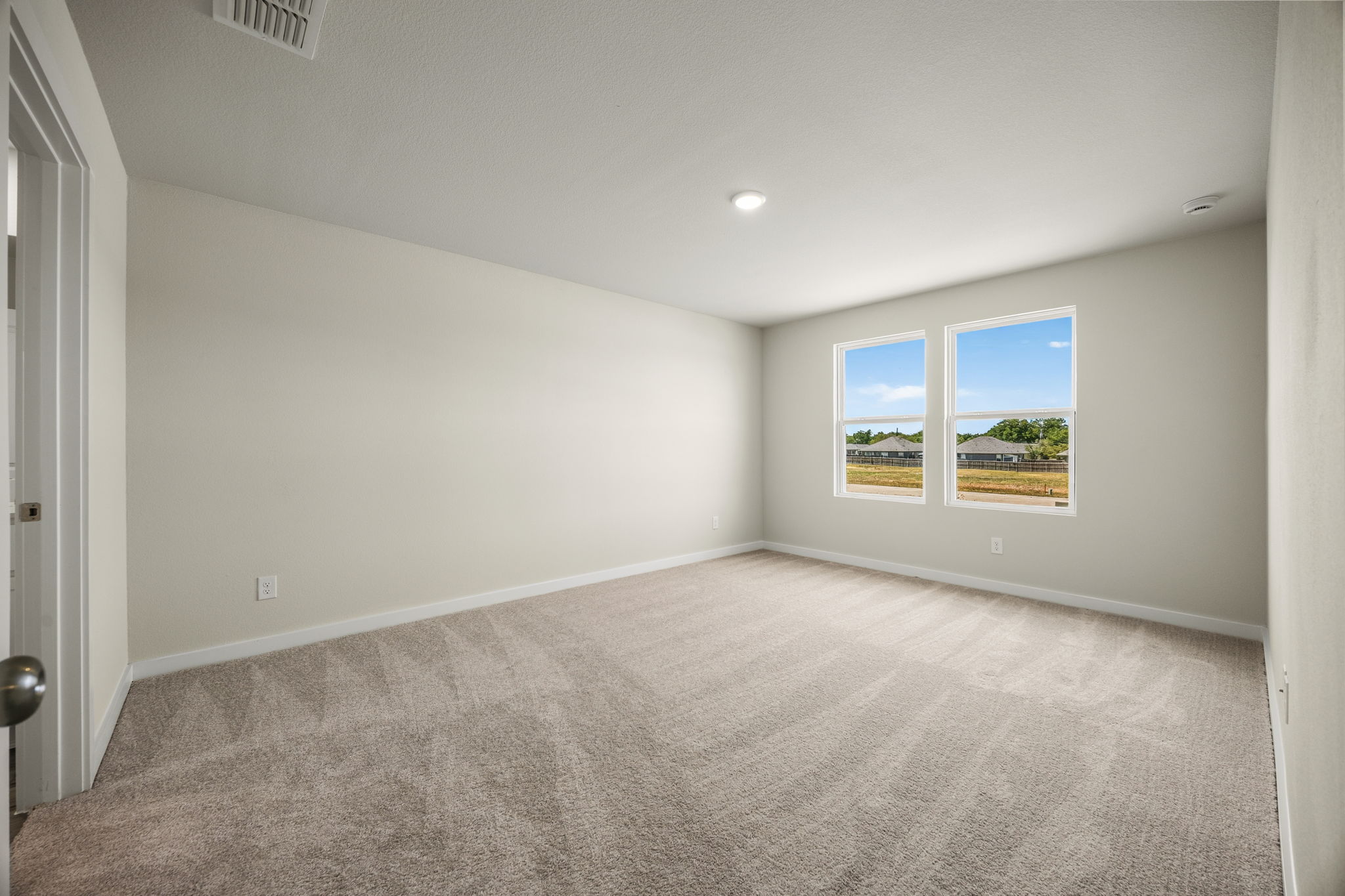 A room with a carpet and a window.