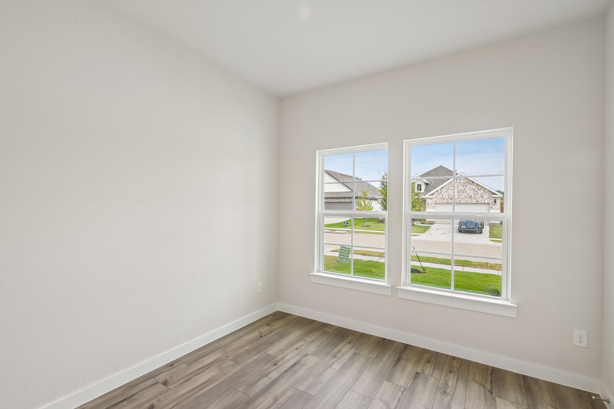 A room with a window and a wood floor.
