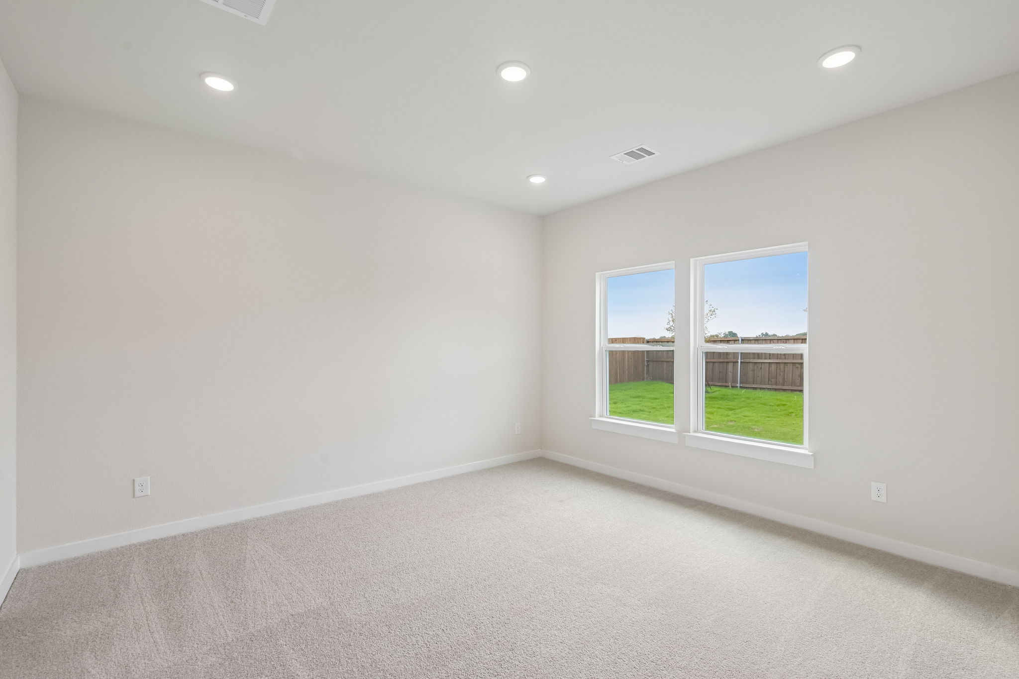 A room with a window and a carpet.