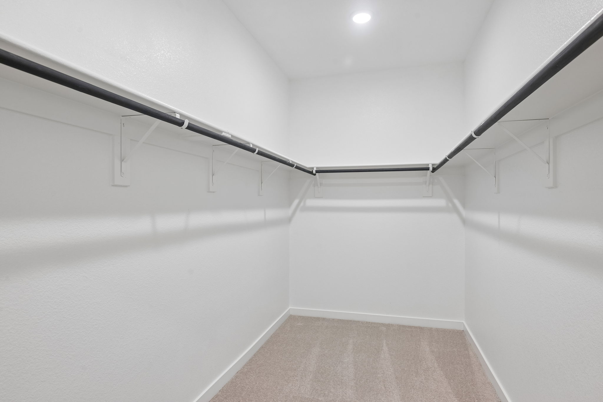 A white hallway with a metal railing.