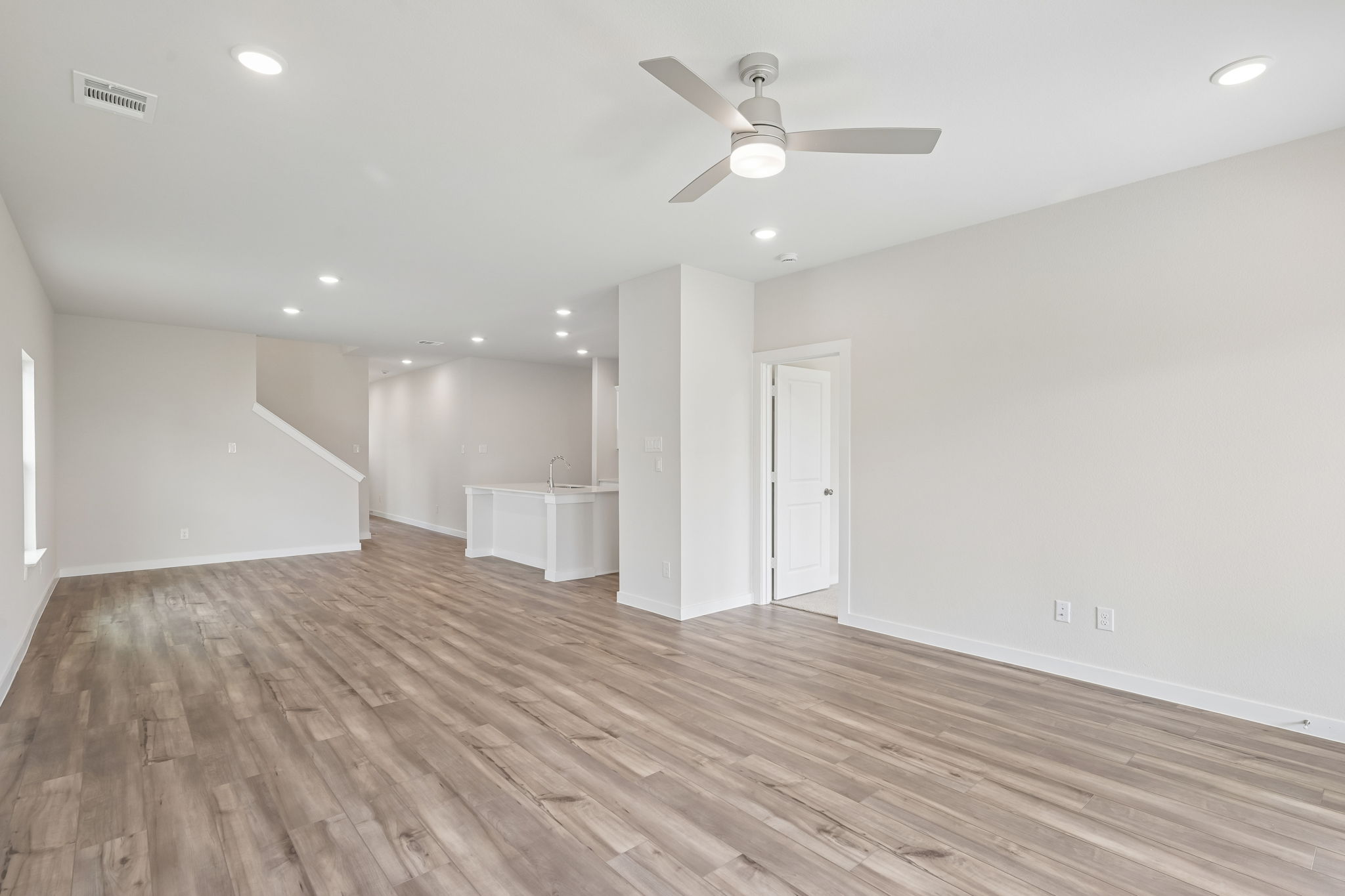 A room with a wood floor and a ceiling fan.