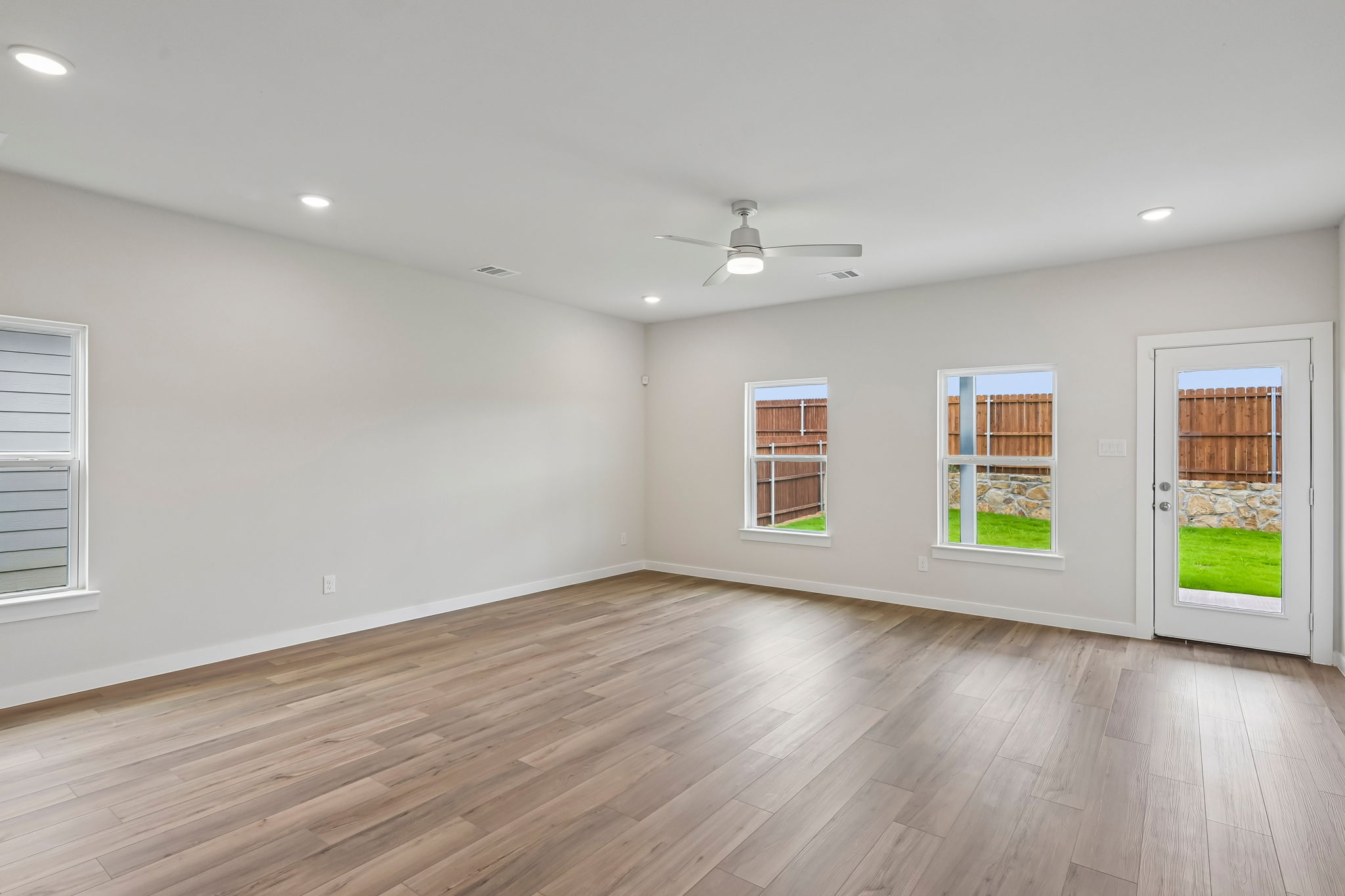 A room with a wood floor and windows.