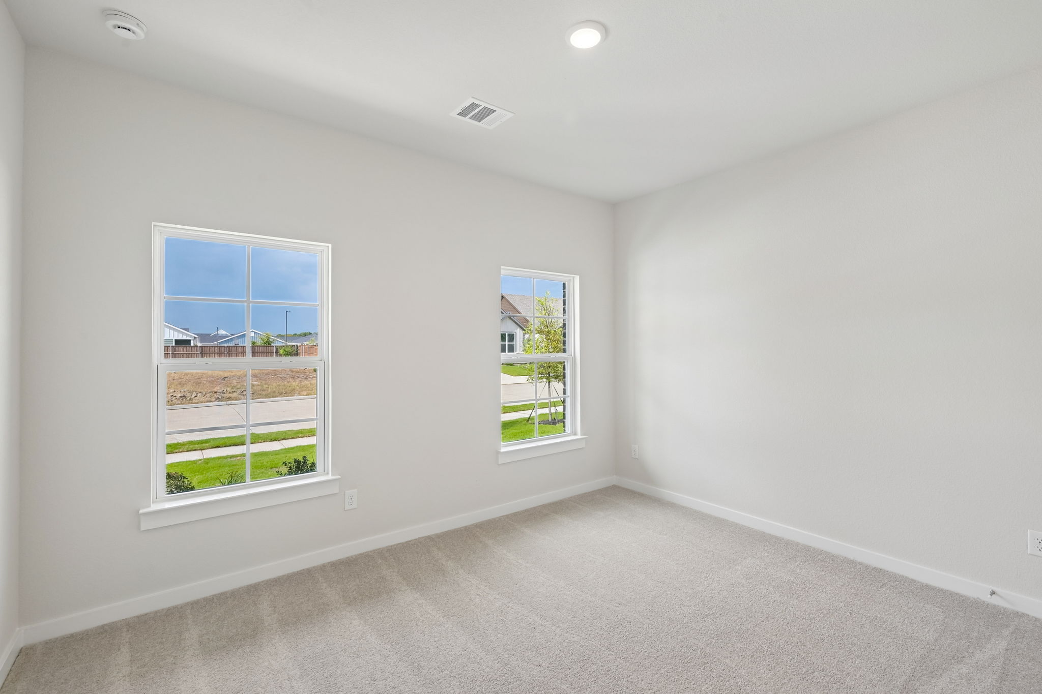 A room with windows and a carpet.