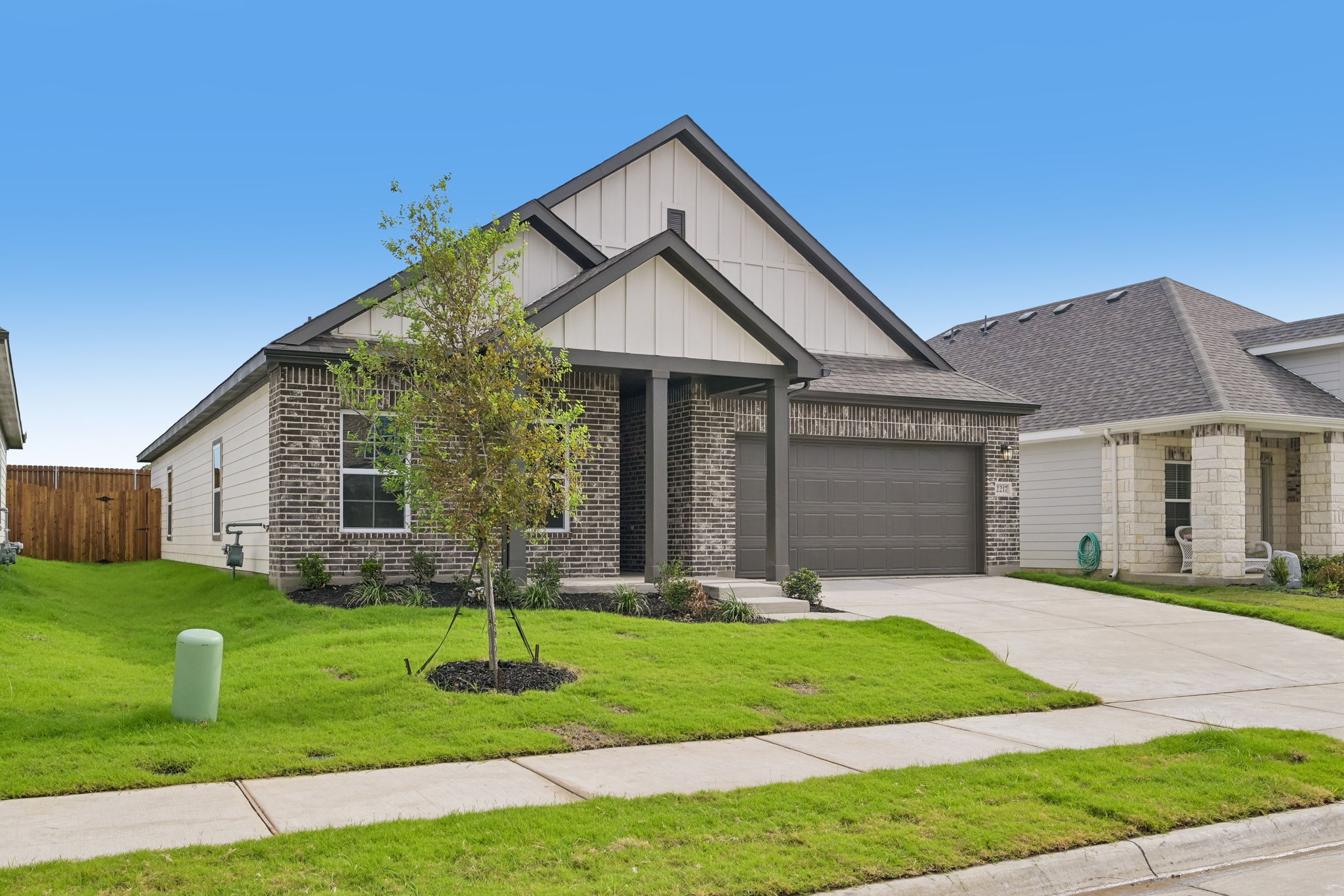 A house with a tree in the front yard.