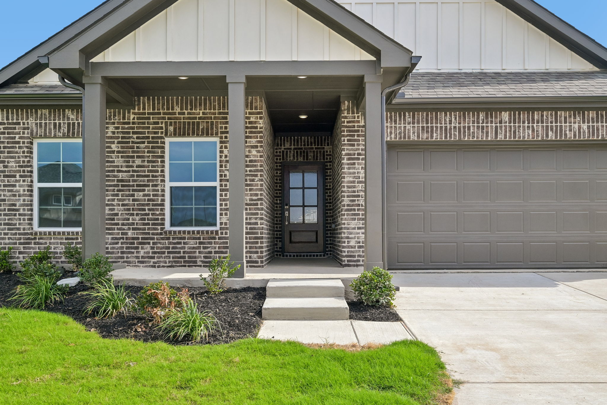 A house with a garage and grass.
