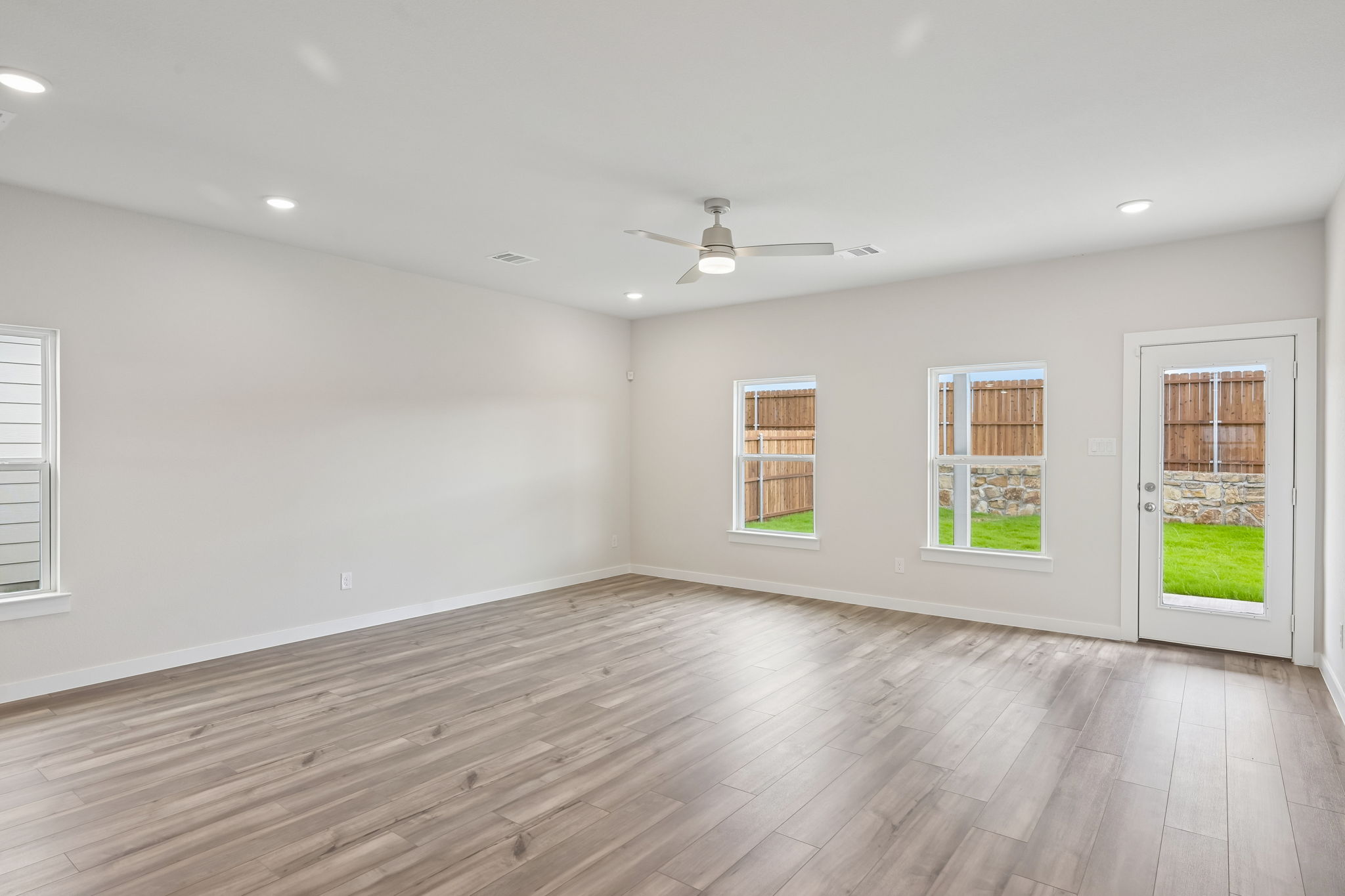 A room with a wood floor and windows.