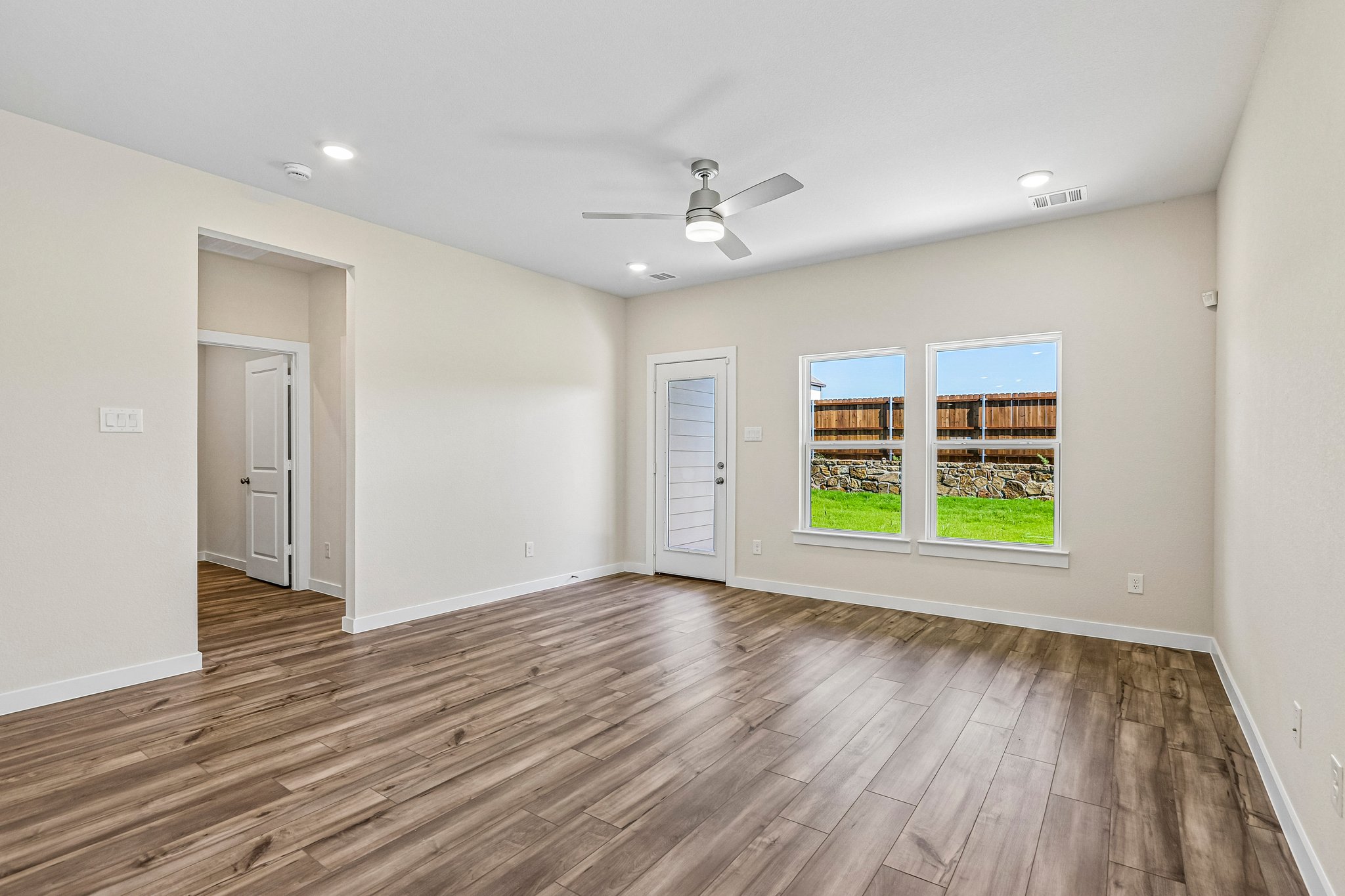 A room with a wood floor and a wood floor with a window.