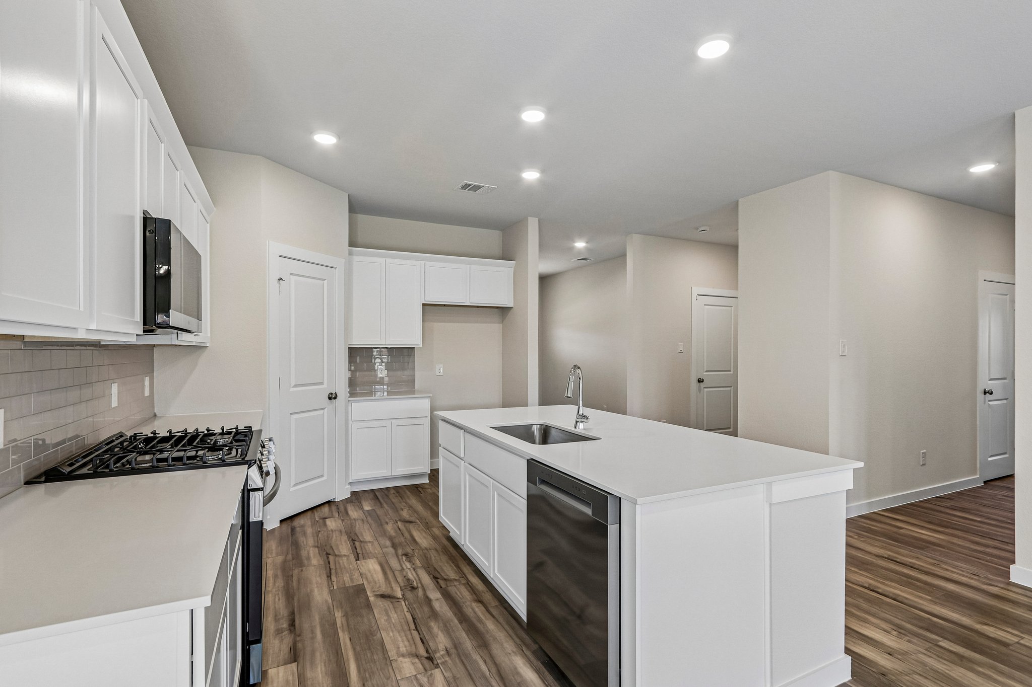 A kitchen with white cabinets.