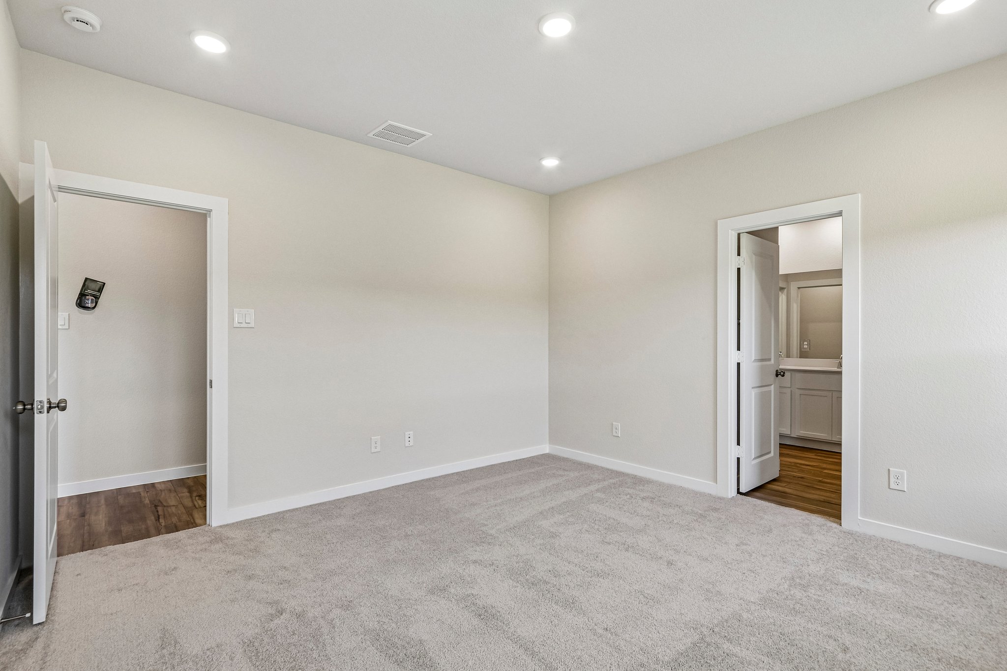 A room with a door and a mirror.