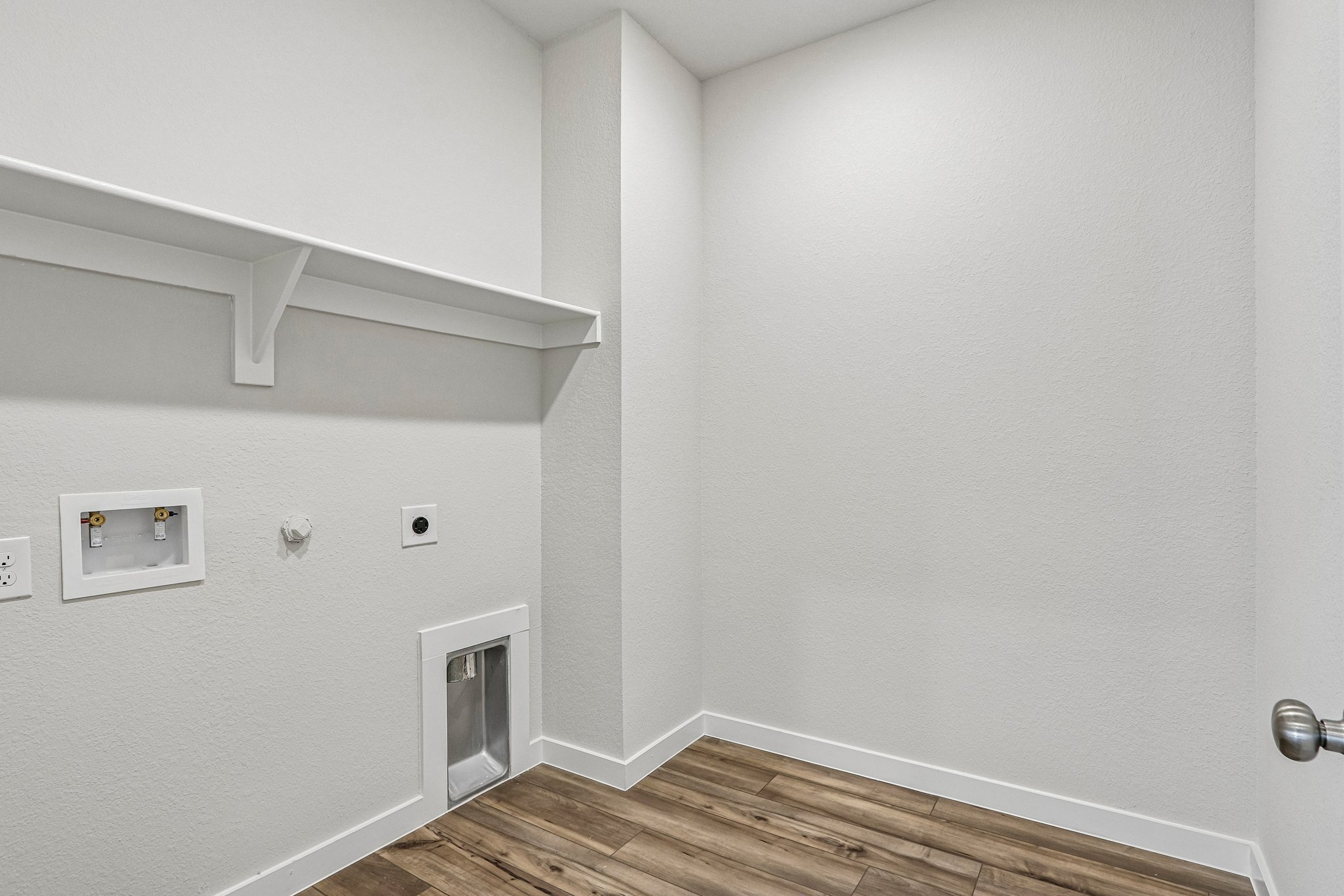 A white room with a wood floor.