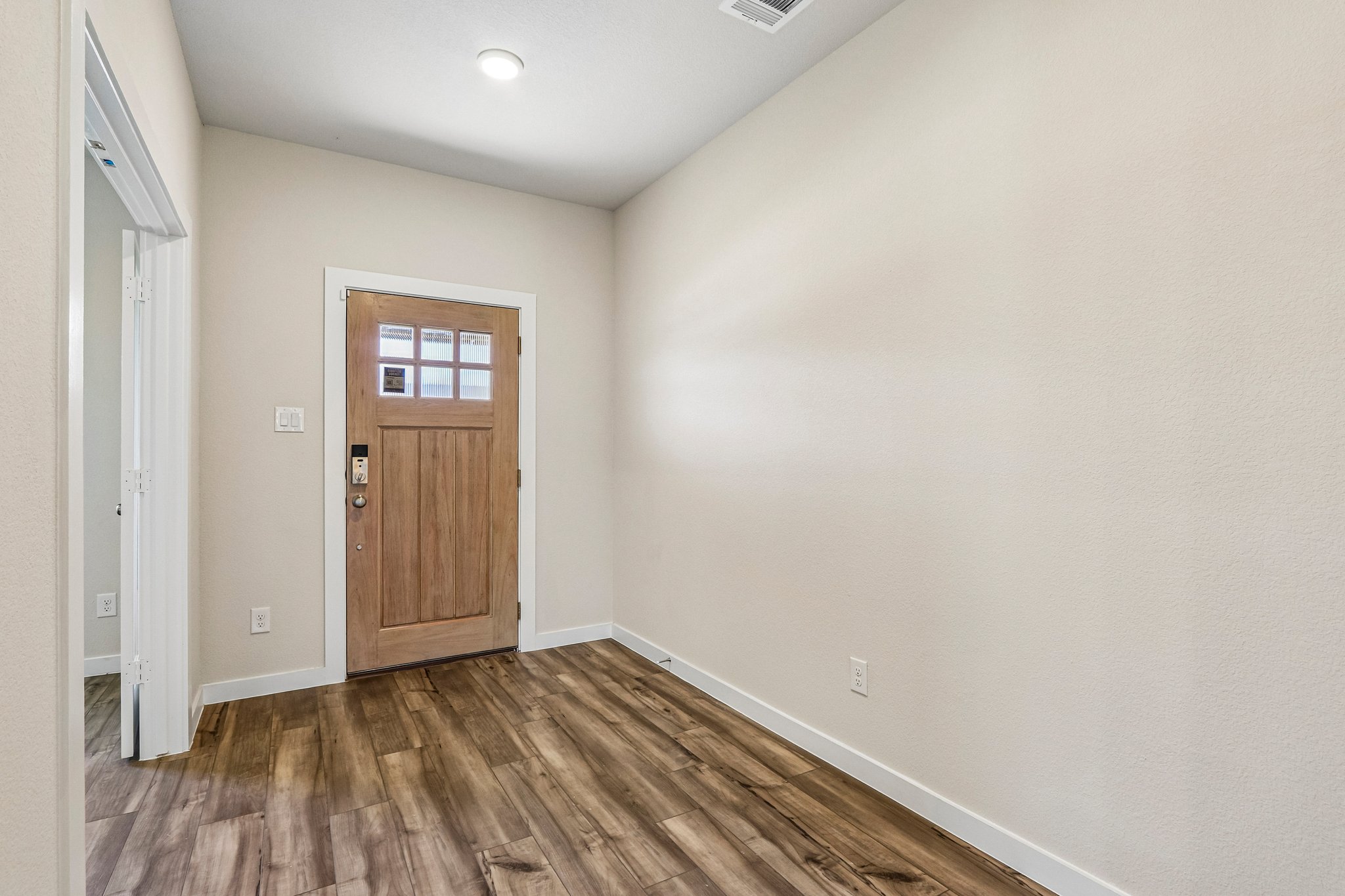 A room with a wood floor and a wood door.