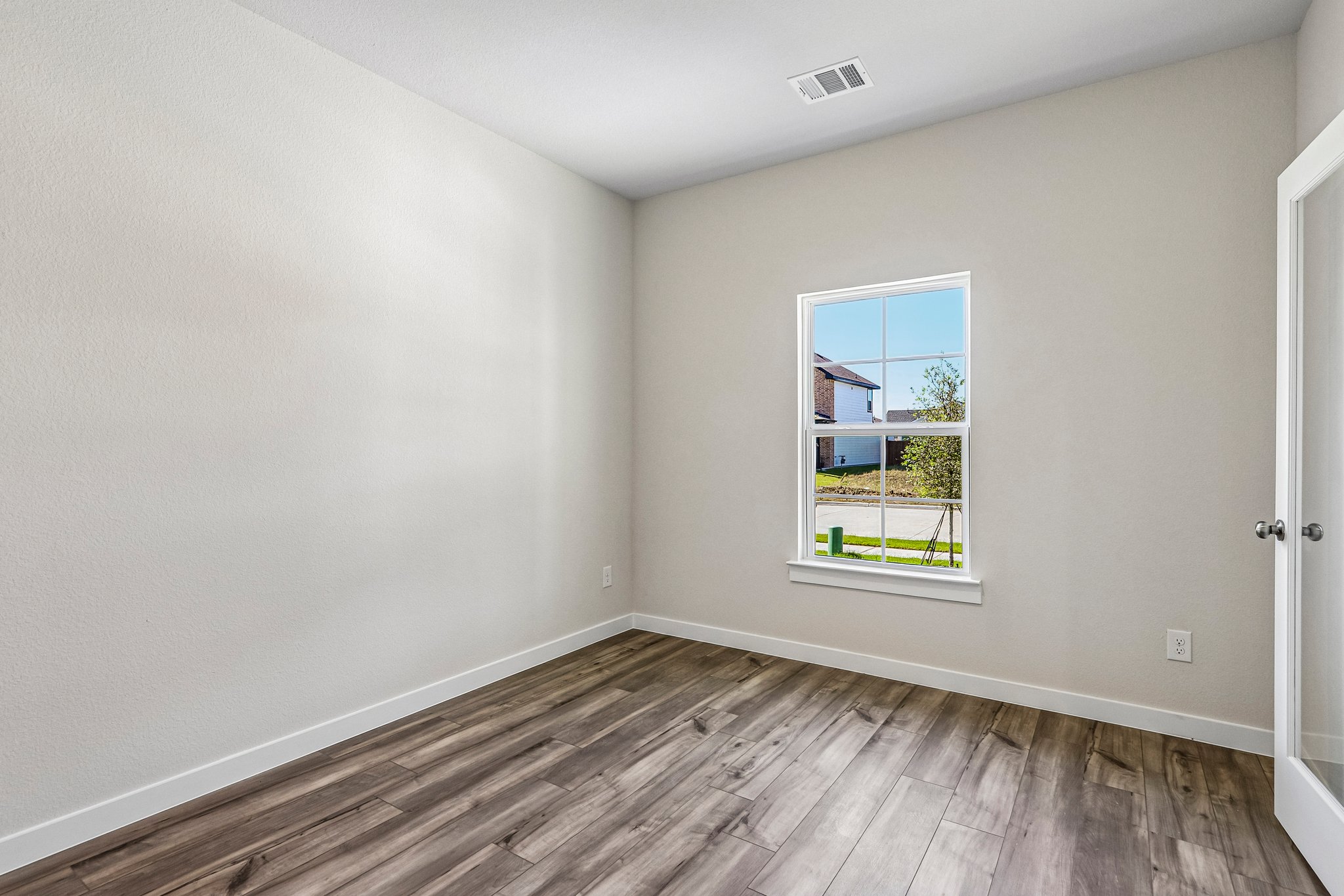 A room with a wood floor and a window with a wood floor.