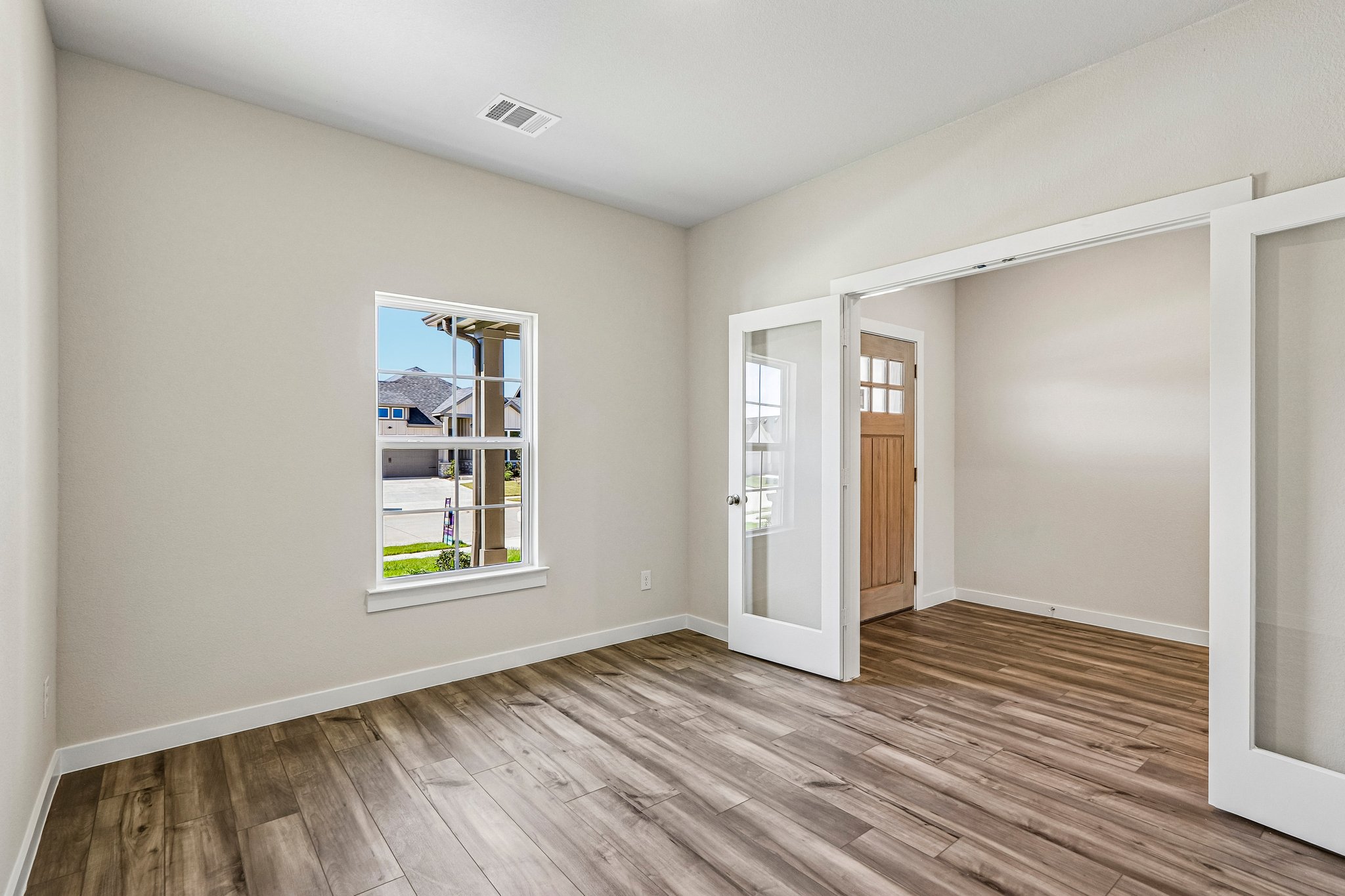 A room with a wood floor and a window.
