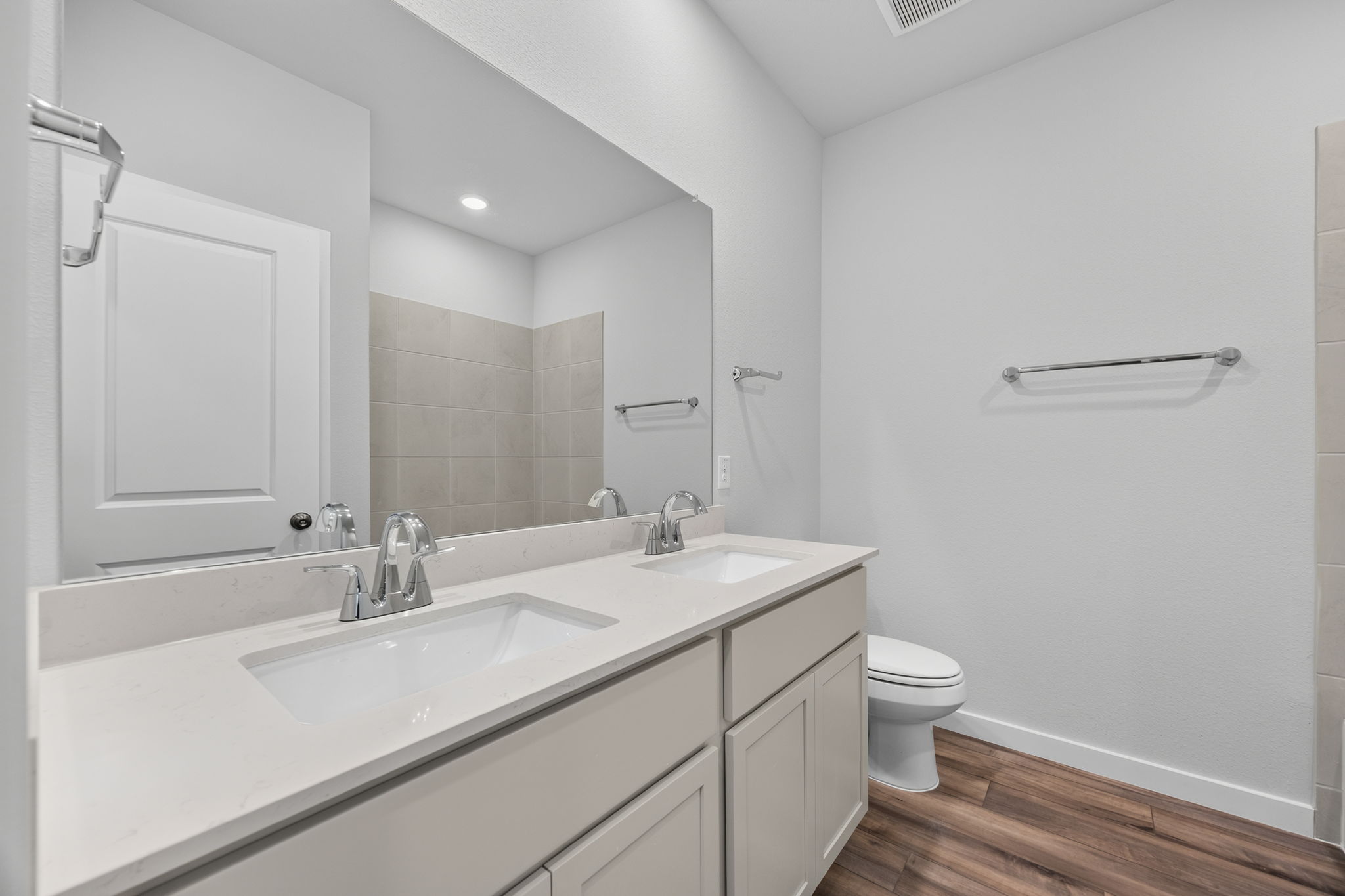 A bathroom with a large mirror.