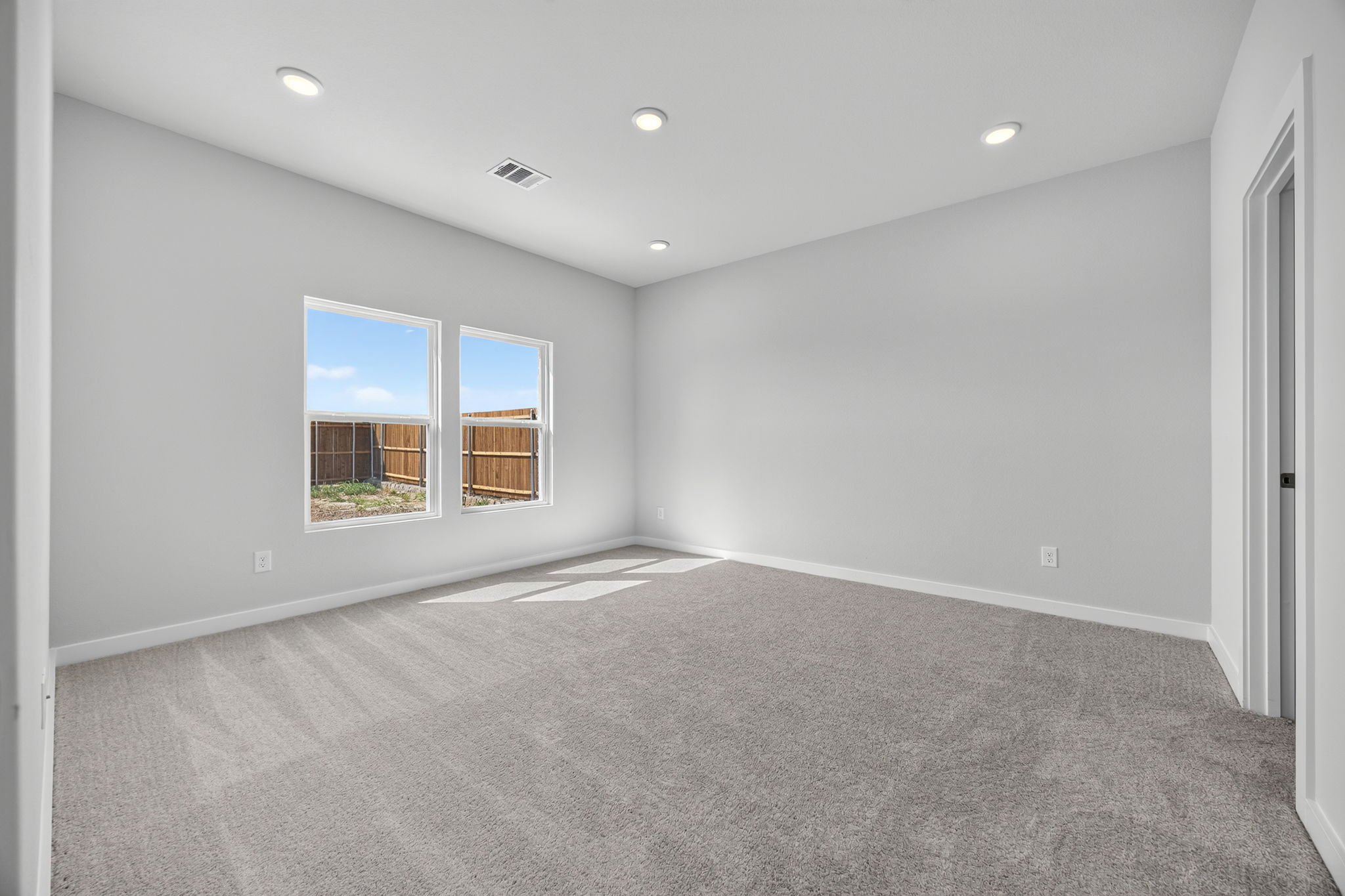 A room with a carpet and windows.
