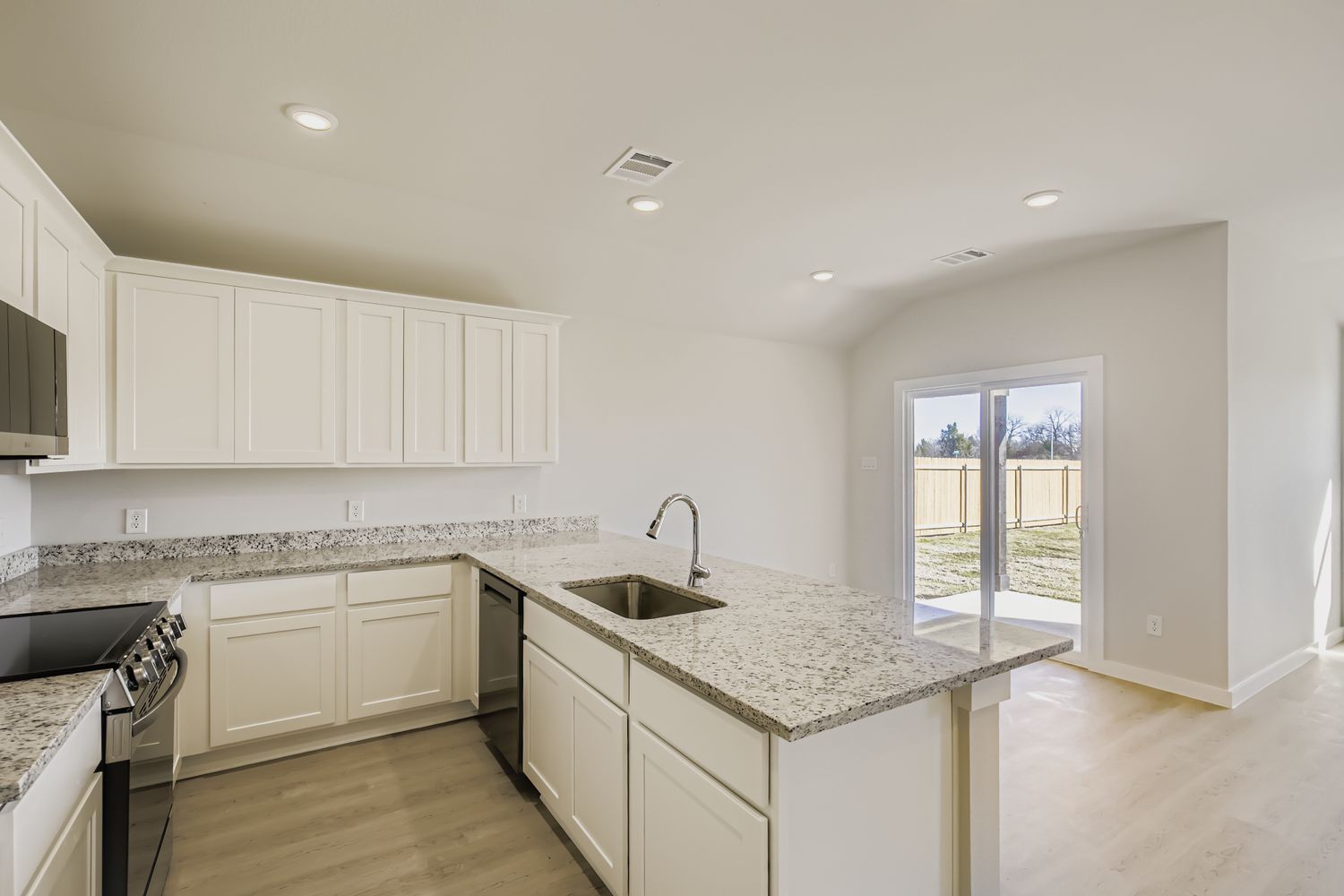 A kitchen with white cabinets.