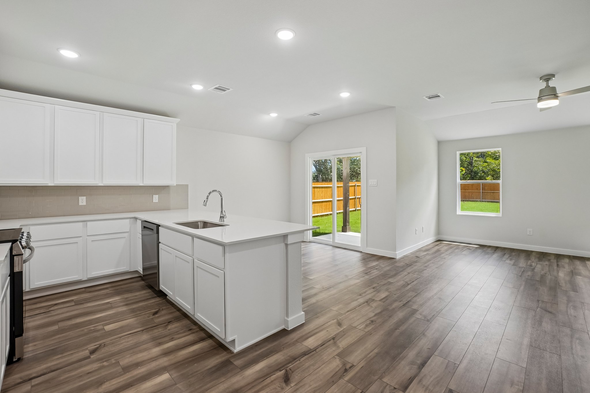 A kitchen with white cabinets.