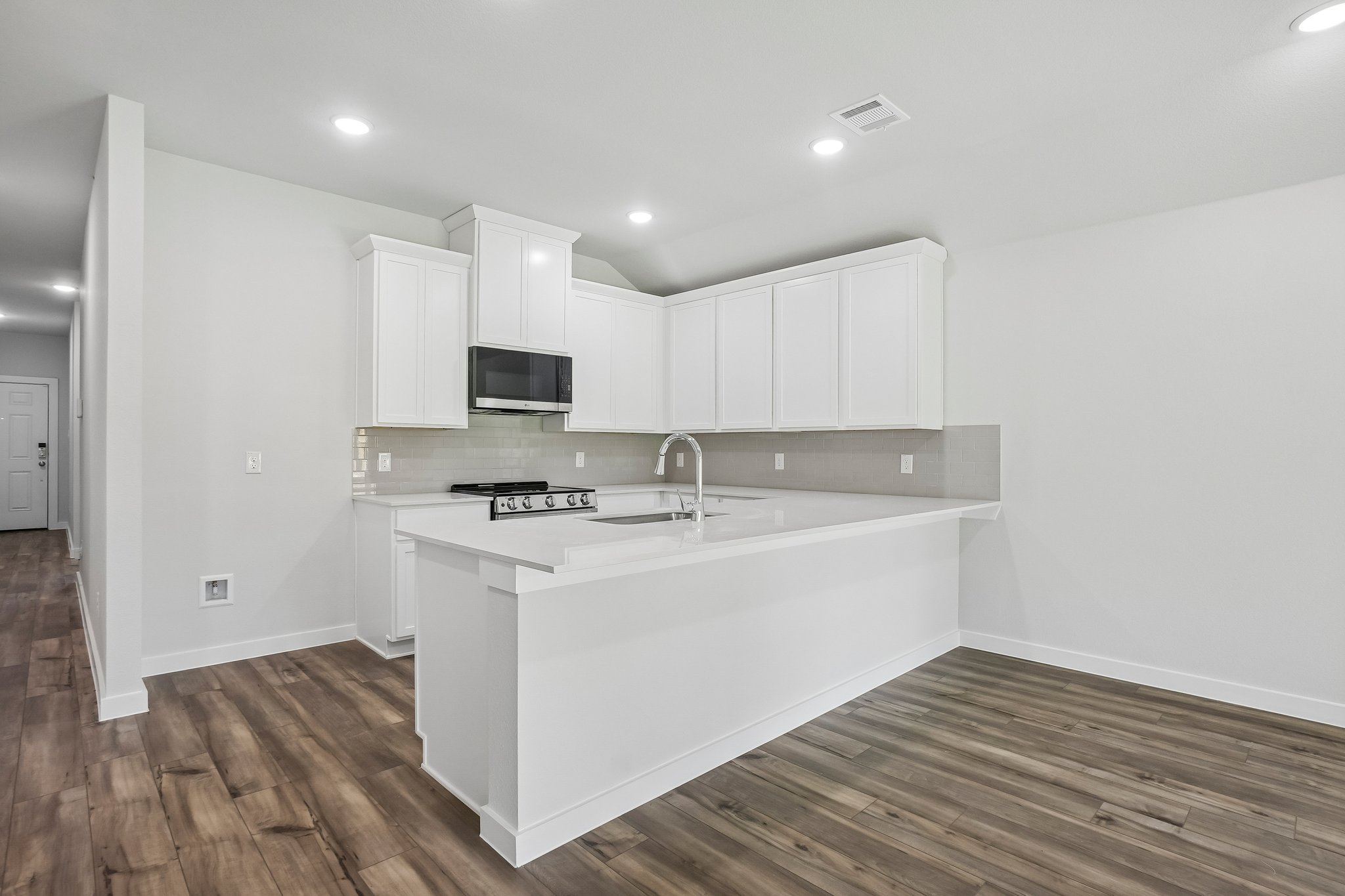 A kitchen with white cabinets.