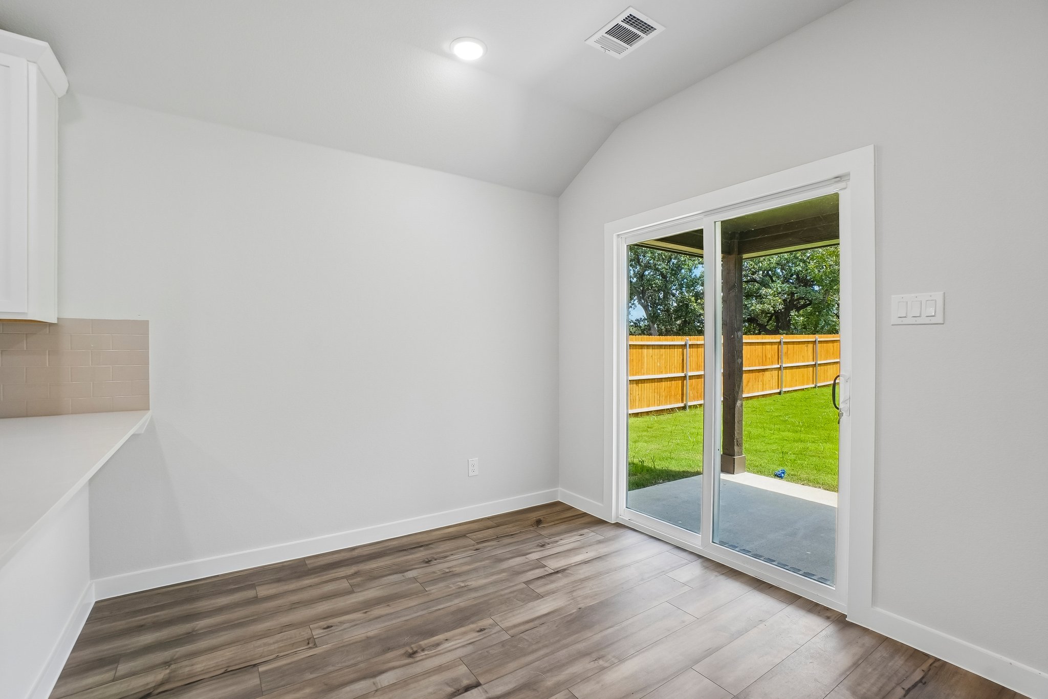 A room with a wood floor and a glass door.