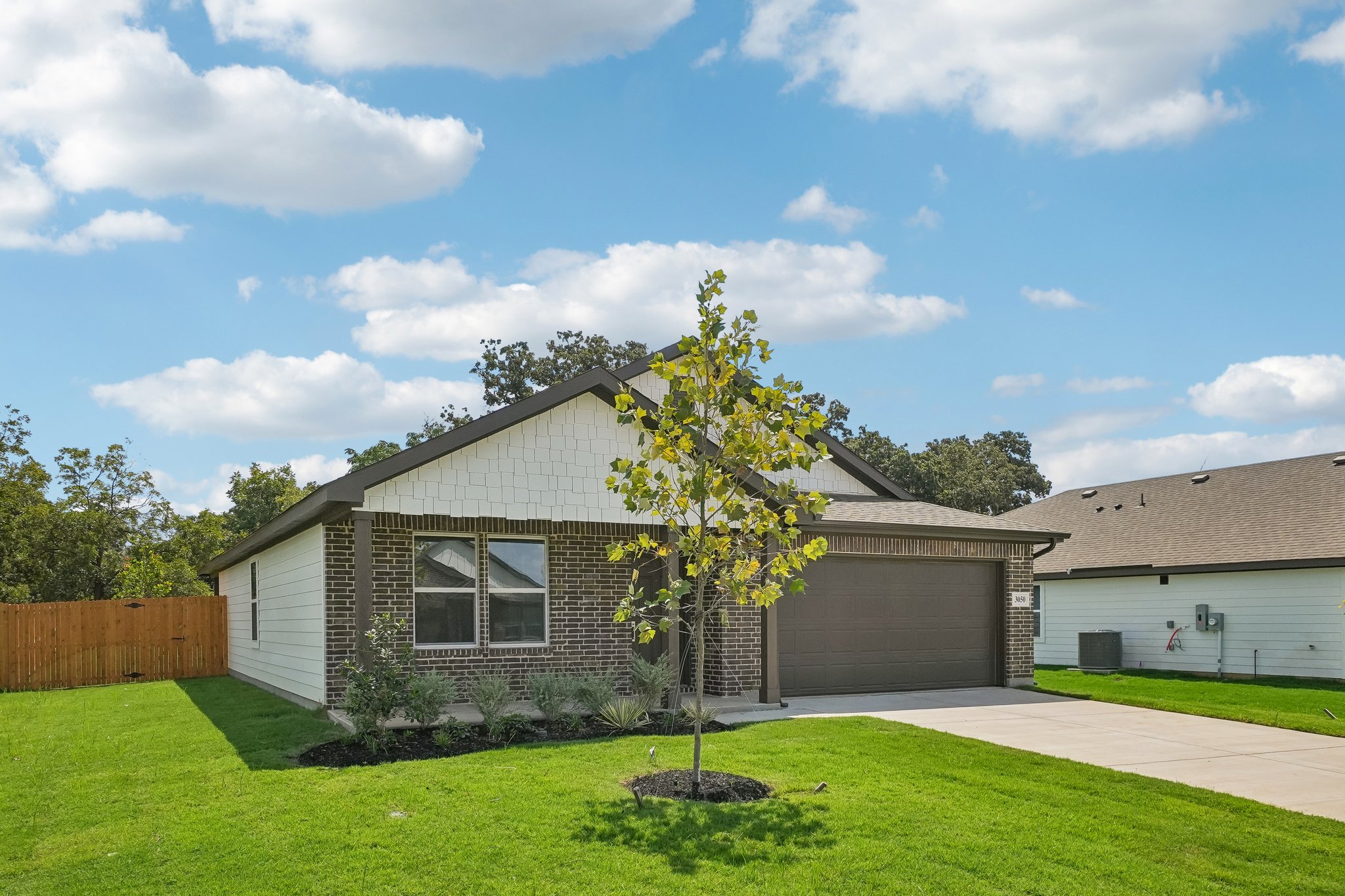 A house with a tree in the front yard.