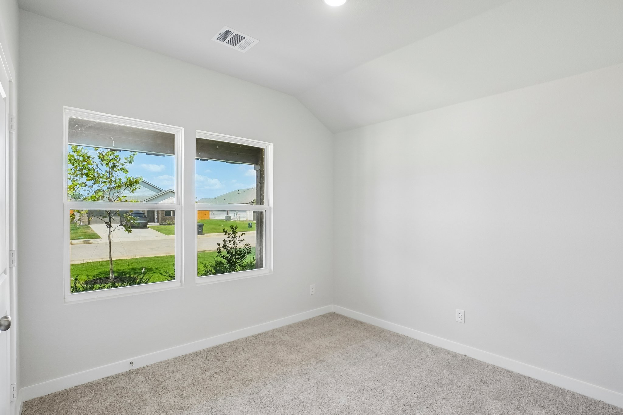 A room with a window and a carpet.