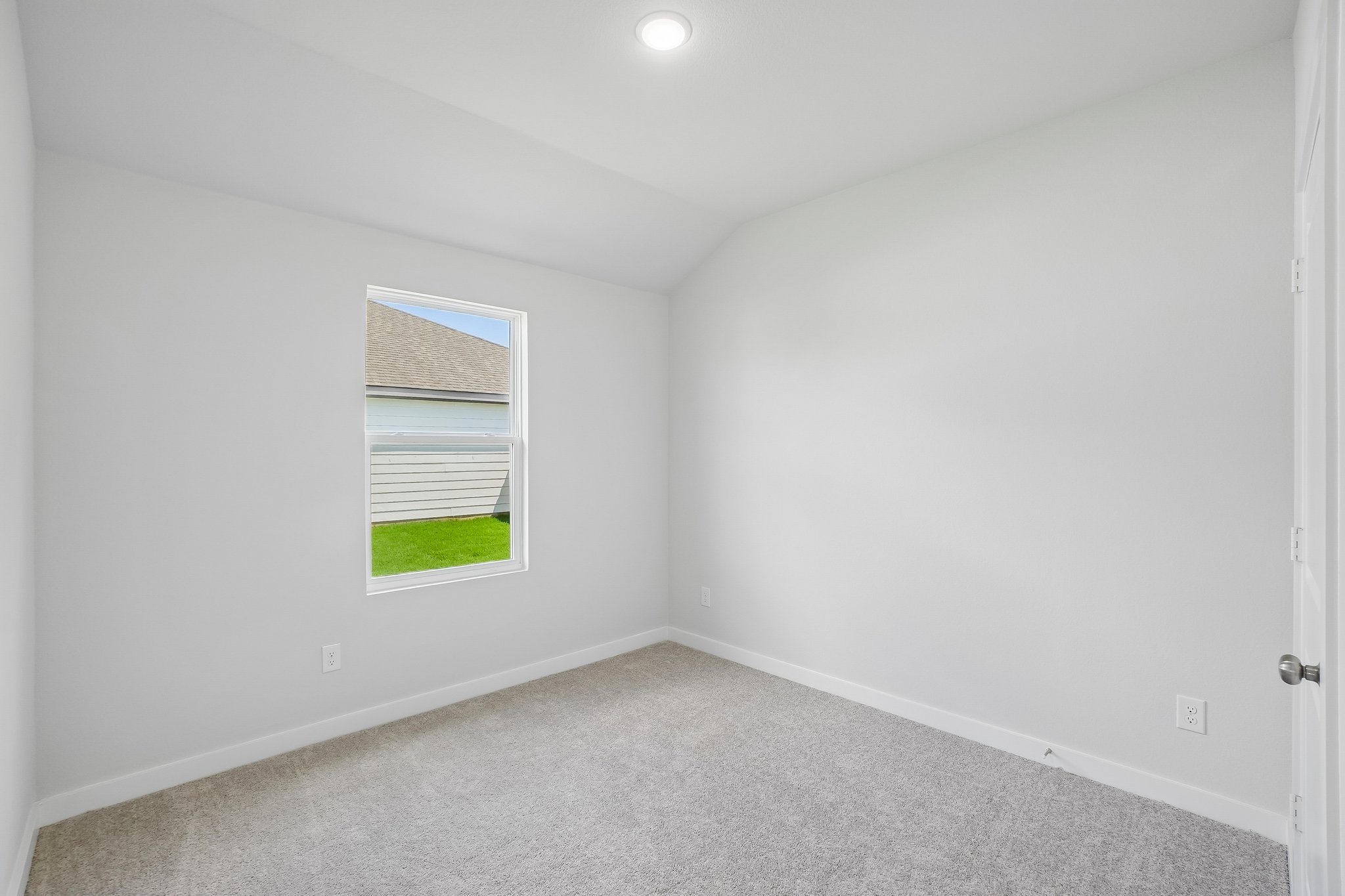 A room with a window and a carpet.