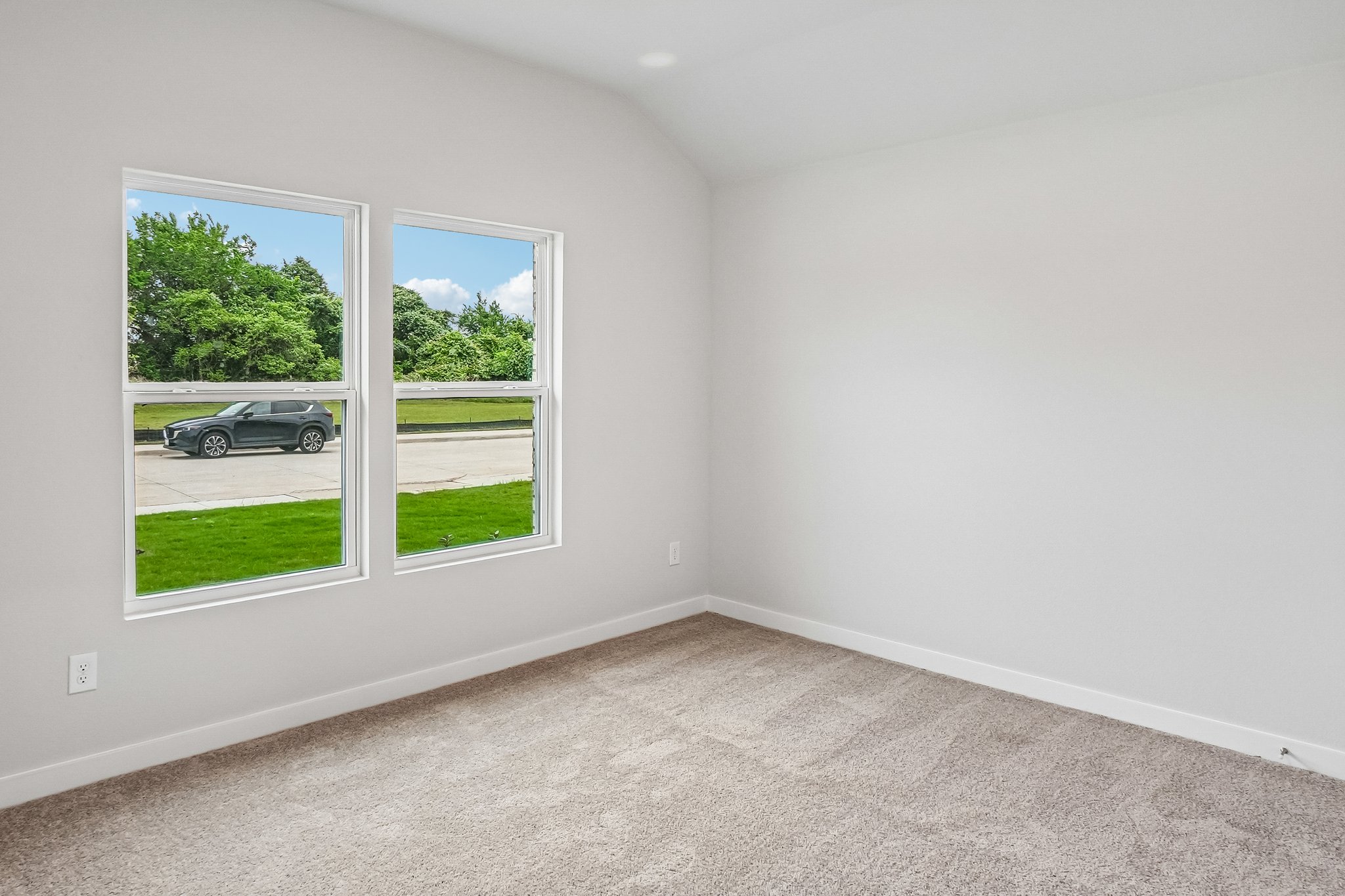 A room with a window and a car outside.
