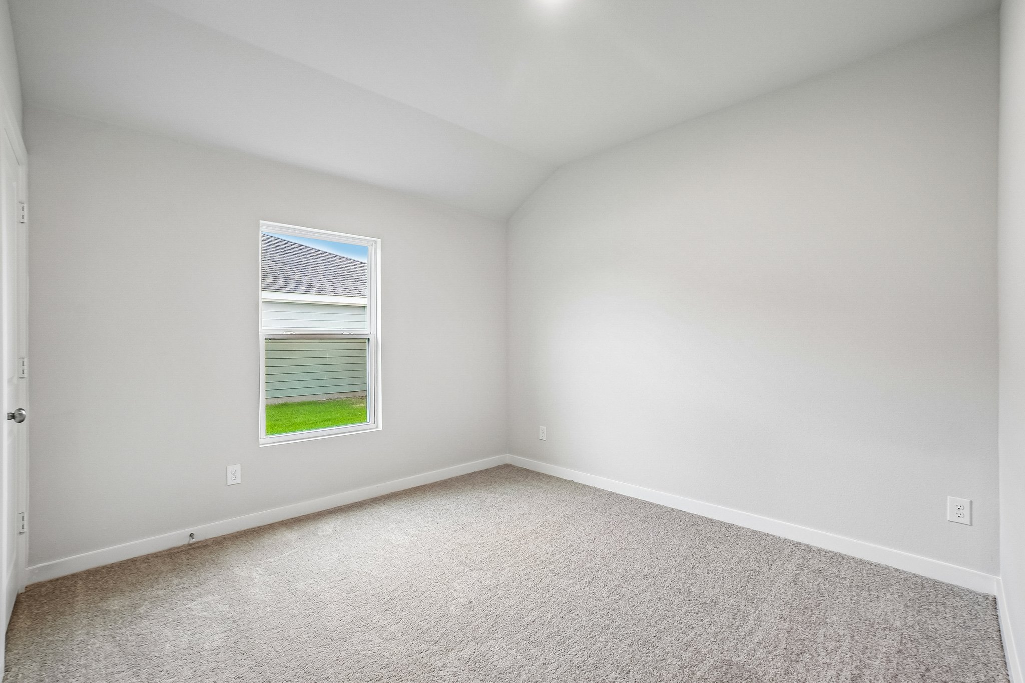 A room with a window and carpet.