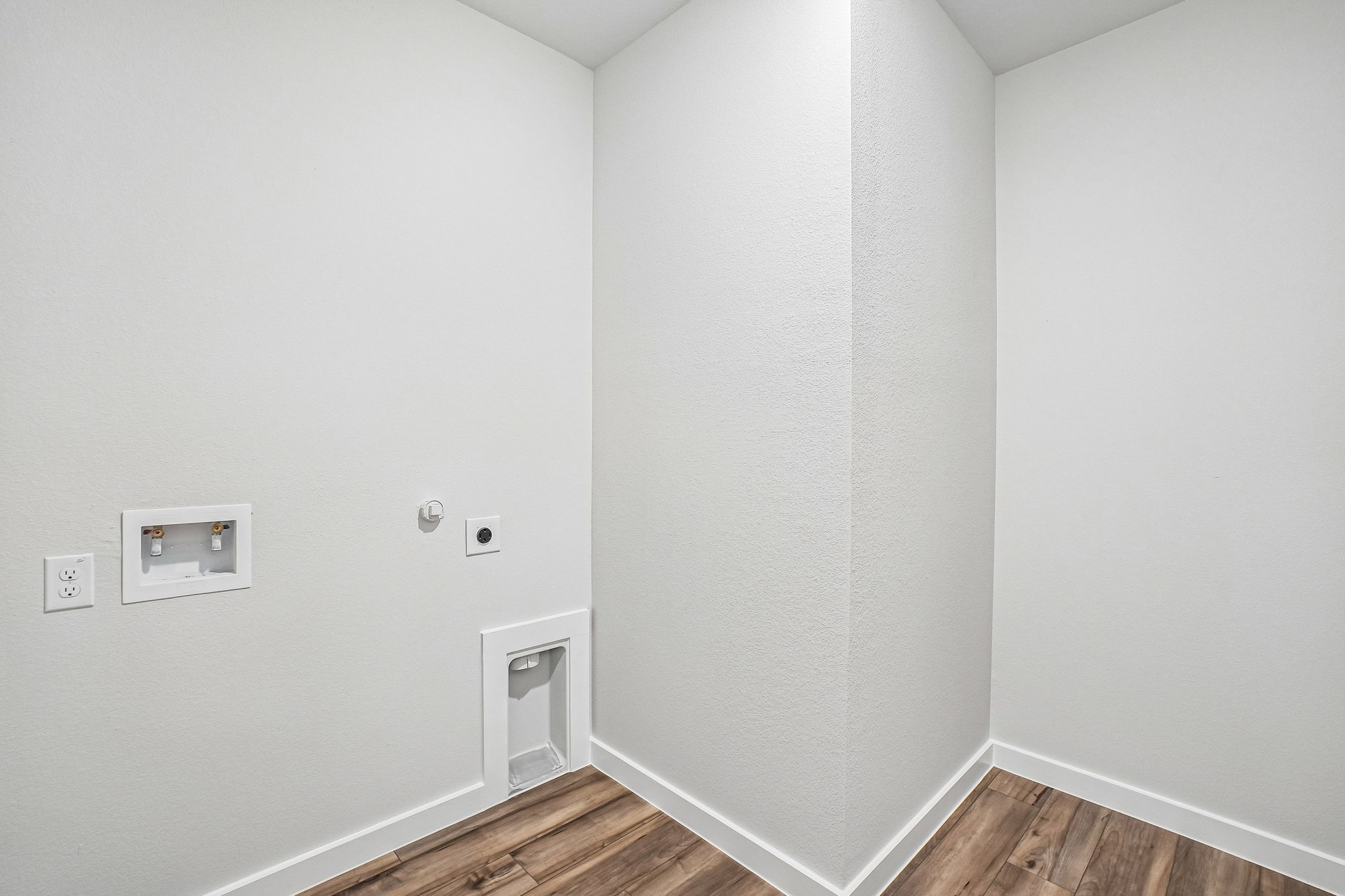 A white room with a wood floor.