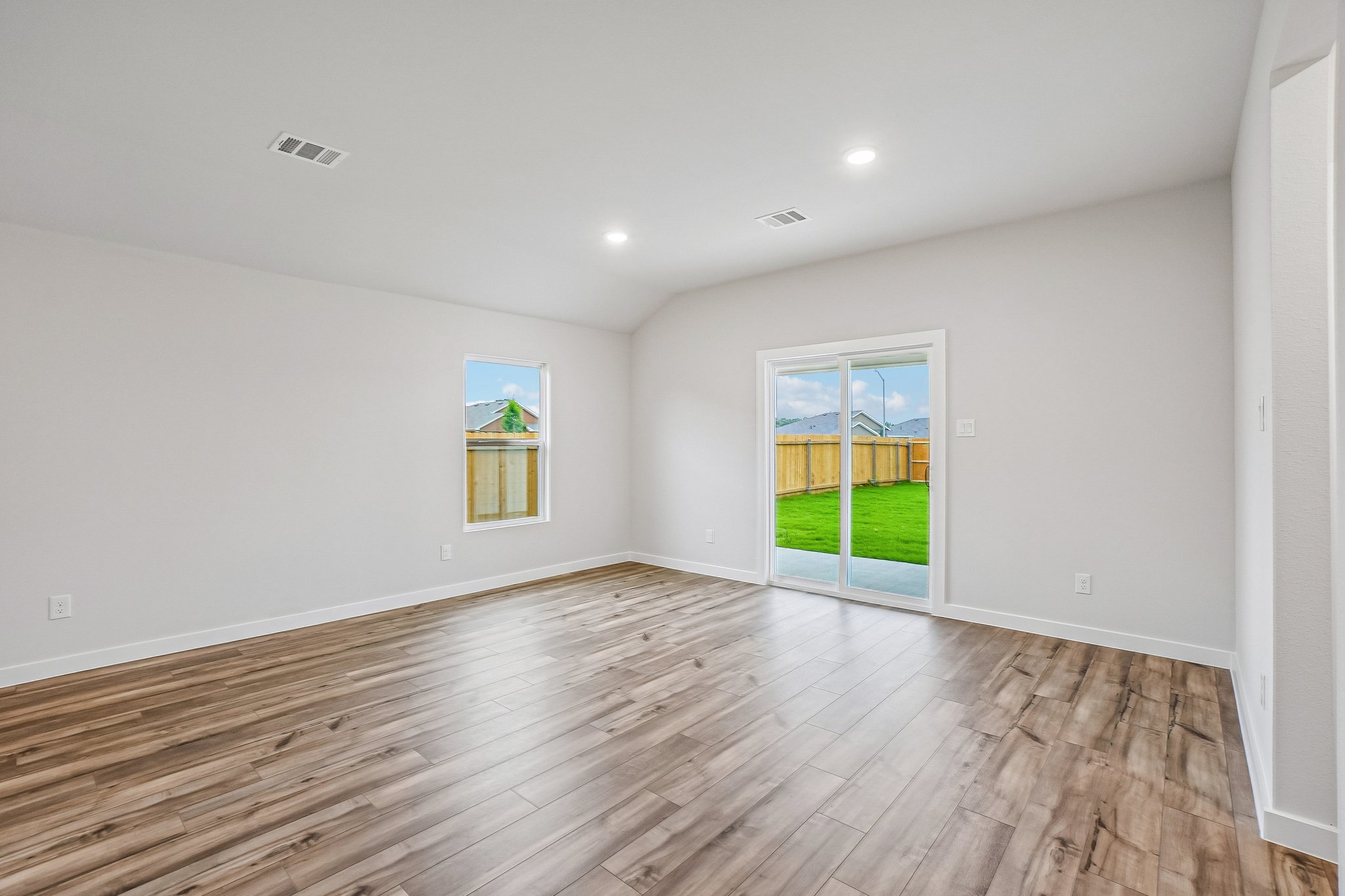 A room with a wood floor and a wood floor with a window.