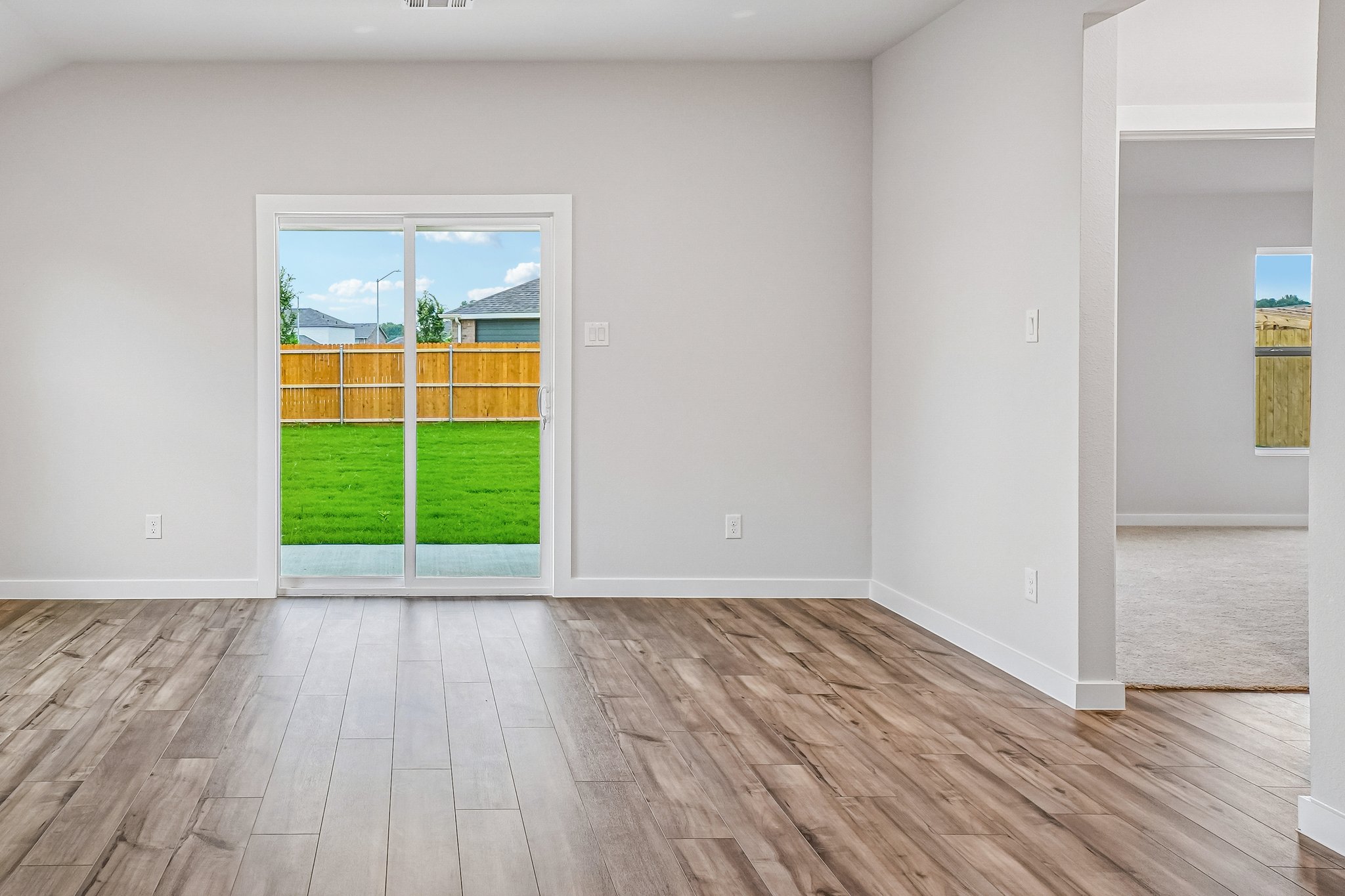 A room with a wood floor and a wood floor with a window.