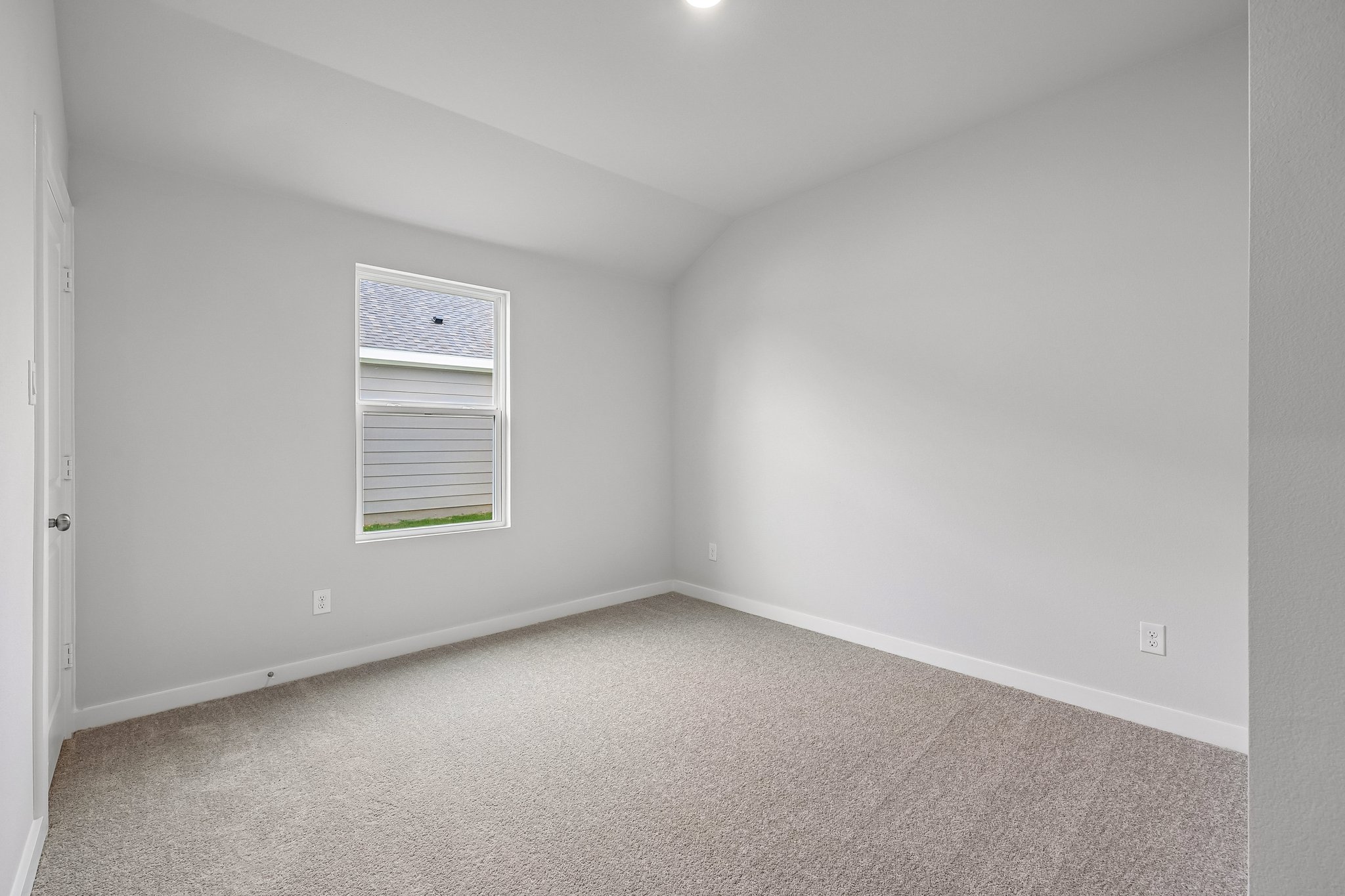 A room with a carpet and a window.