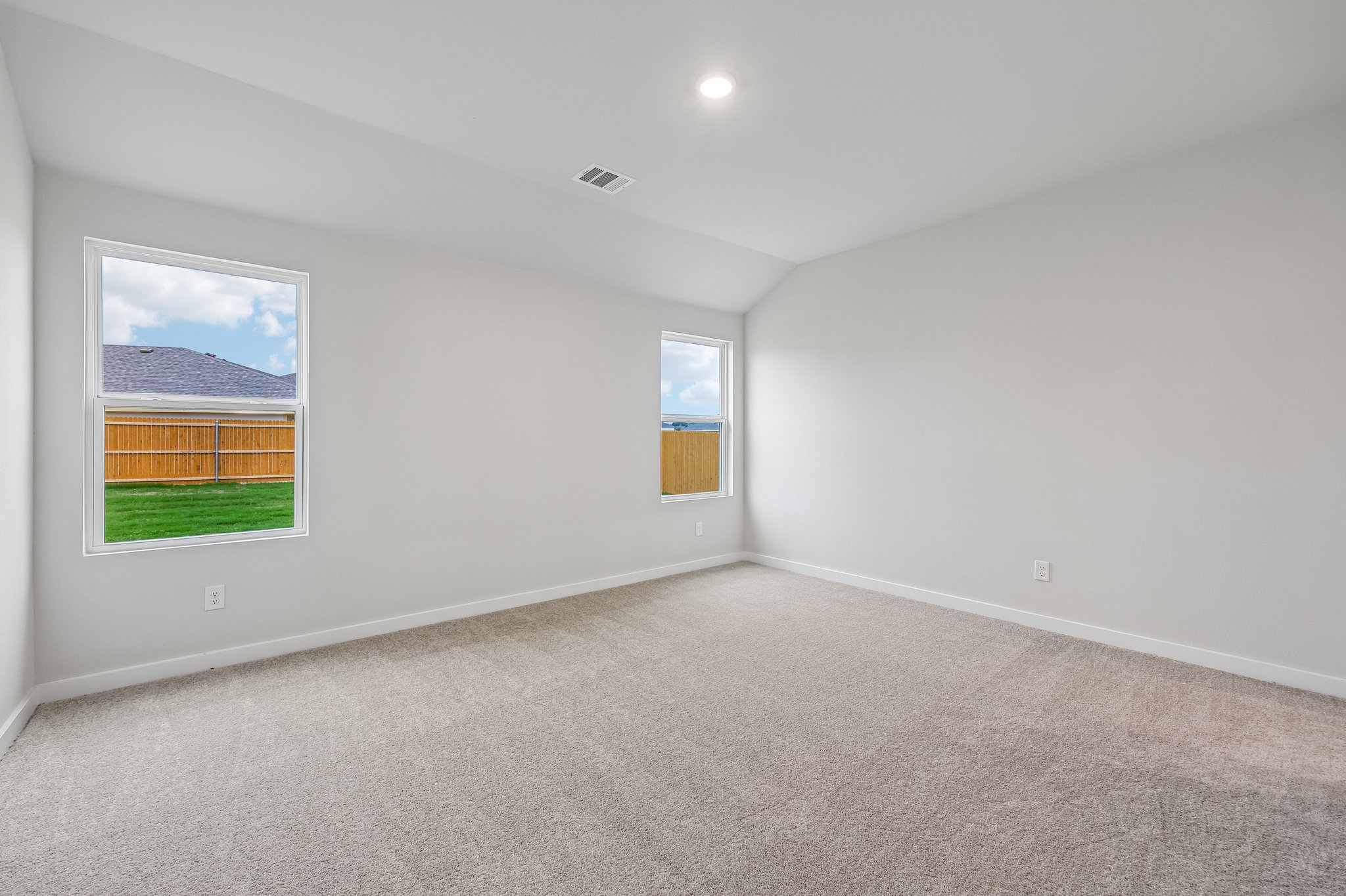 A room with a carpet and windows.
