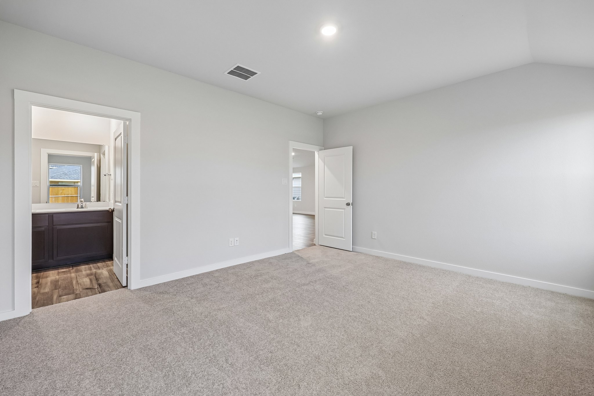 A room with a carpet and a door.