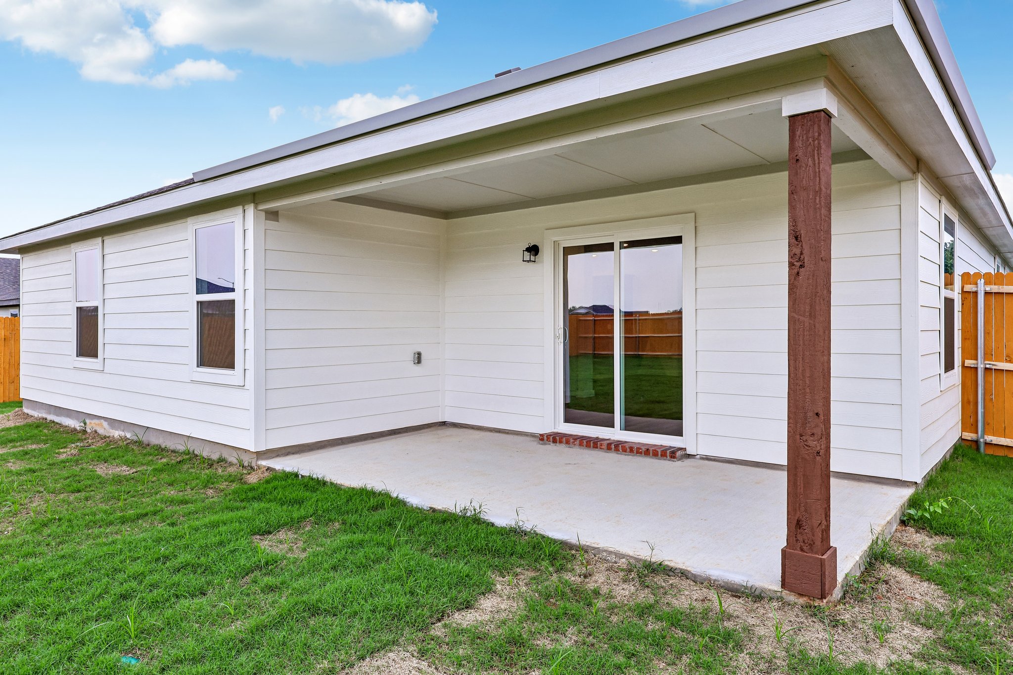A white house with a green lawn.