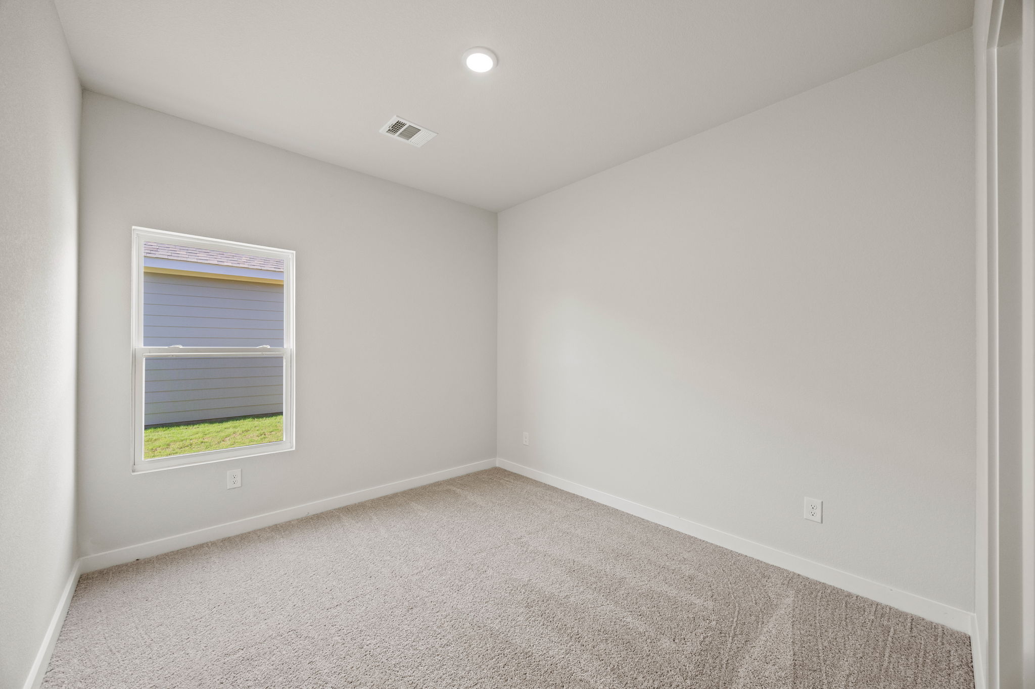 A room with a window and carpet.