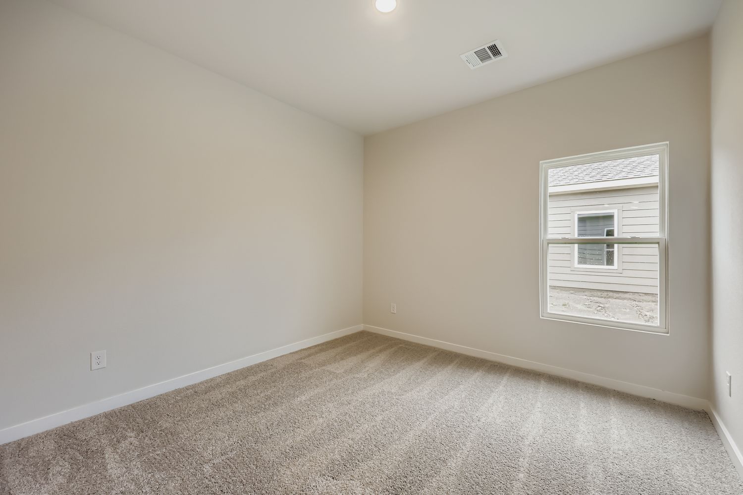 A room with a window and carpet.