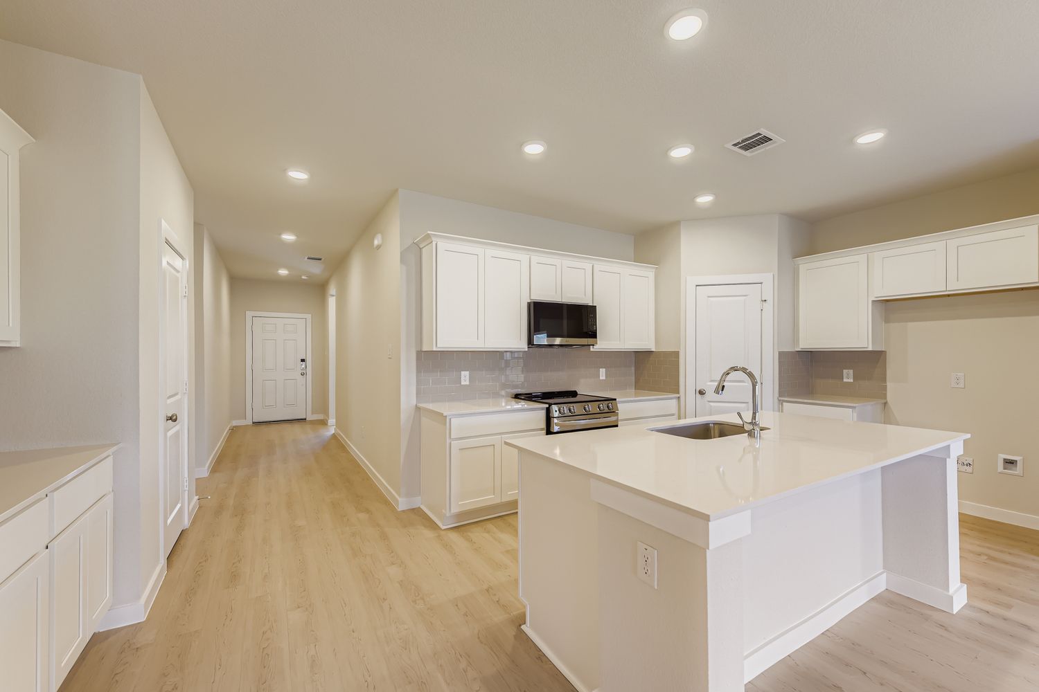 A kitchen with white cabinets.