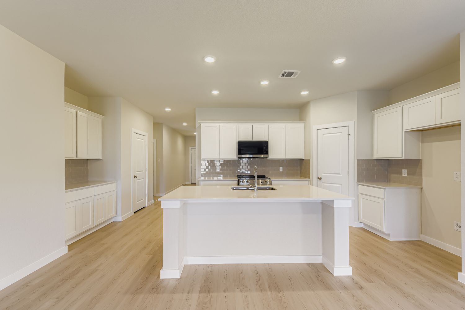 A kitchen with white cabinets.