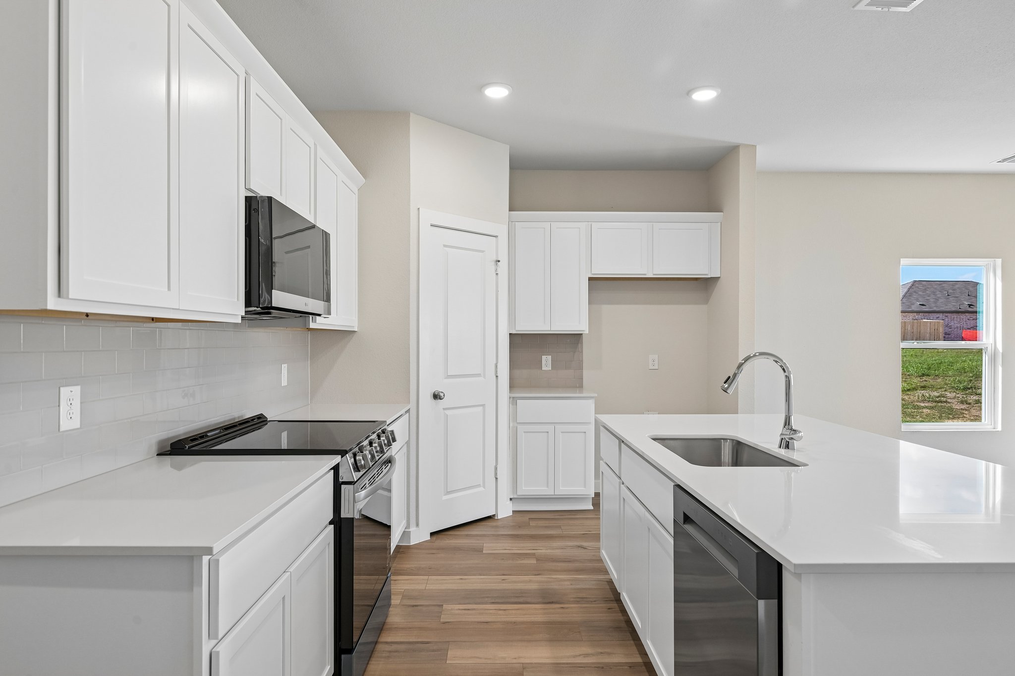 A kitchen with white cabinets.