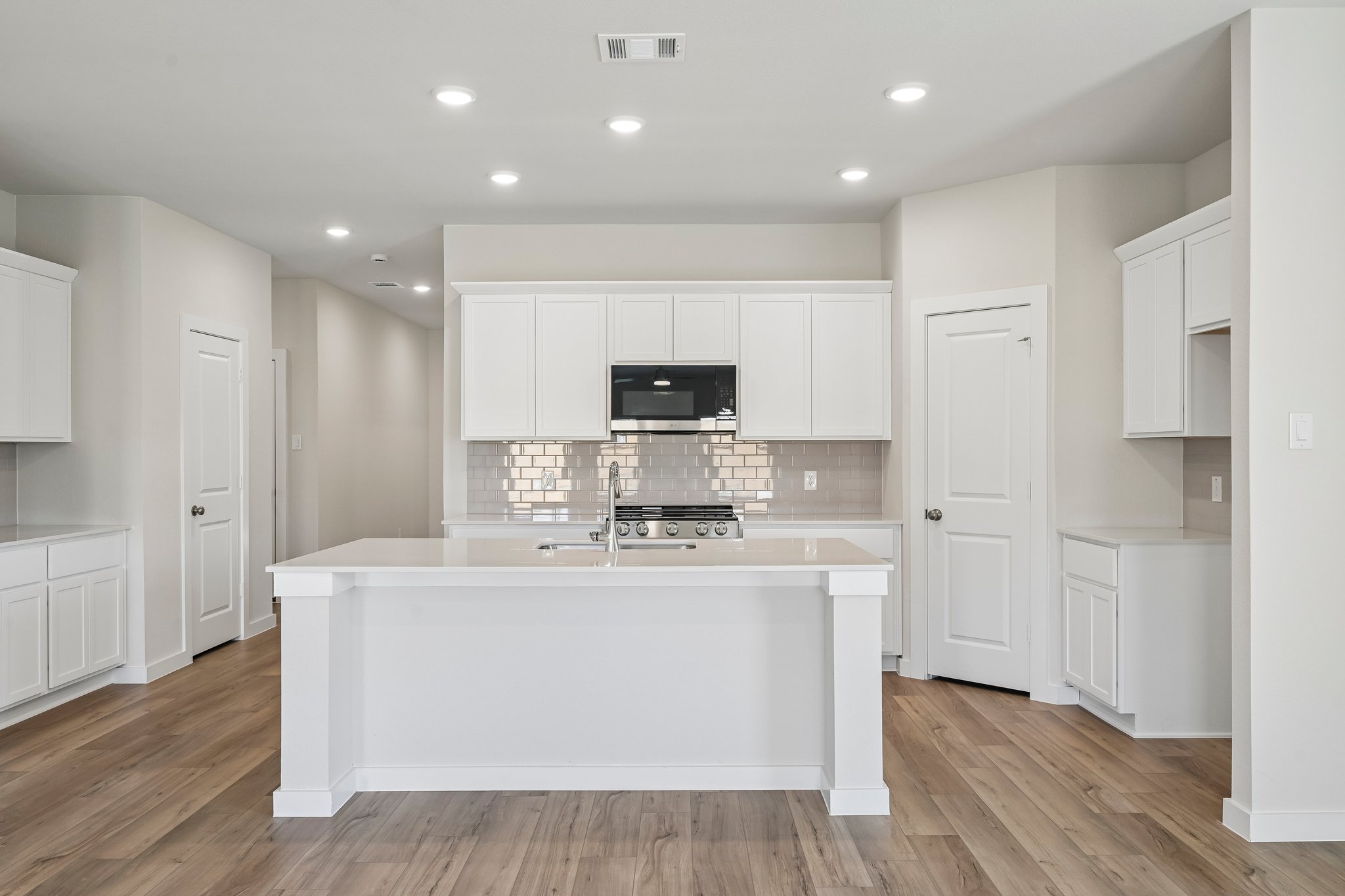 A kitchen with white cabinets.