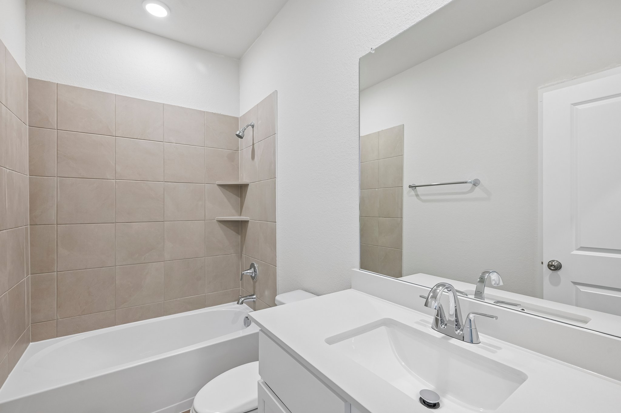 A bathroom with a tub sink and mirror.
