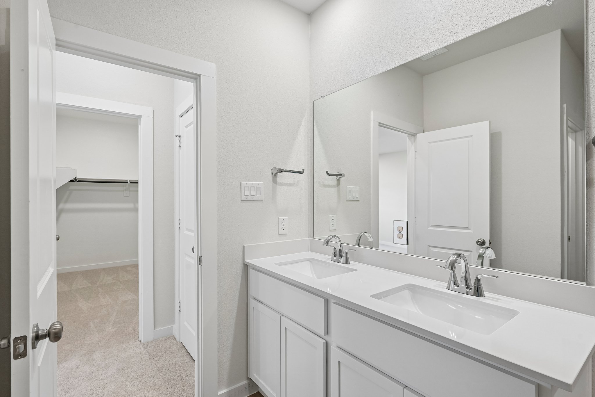 A bathroom with a large mirror.