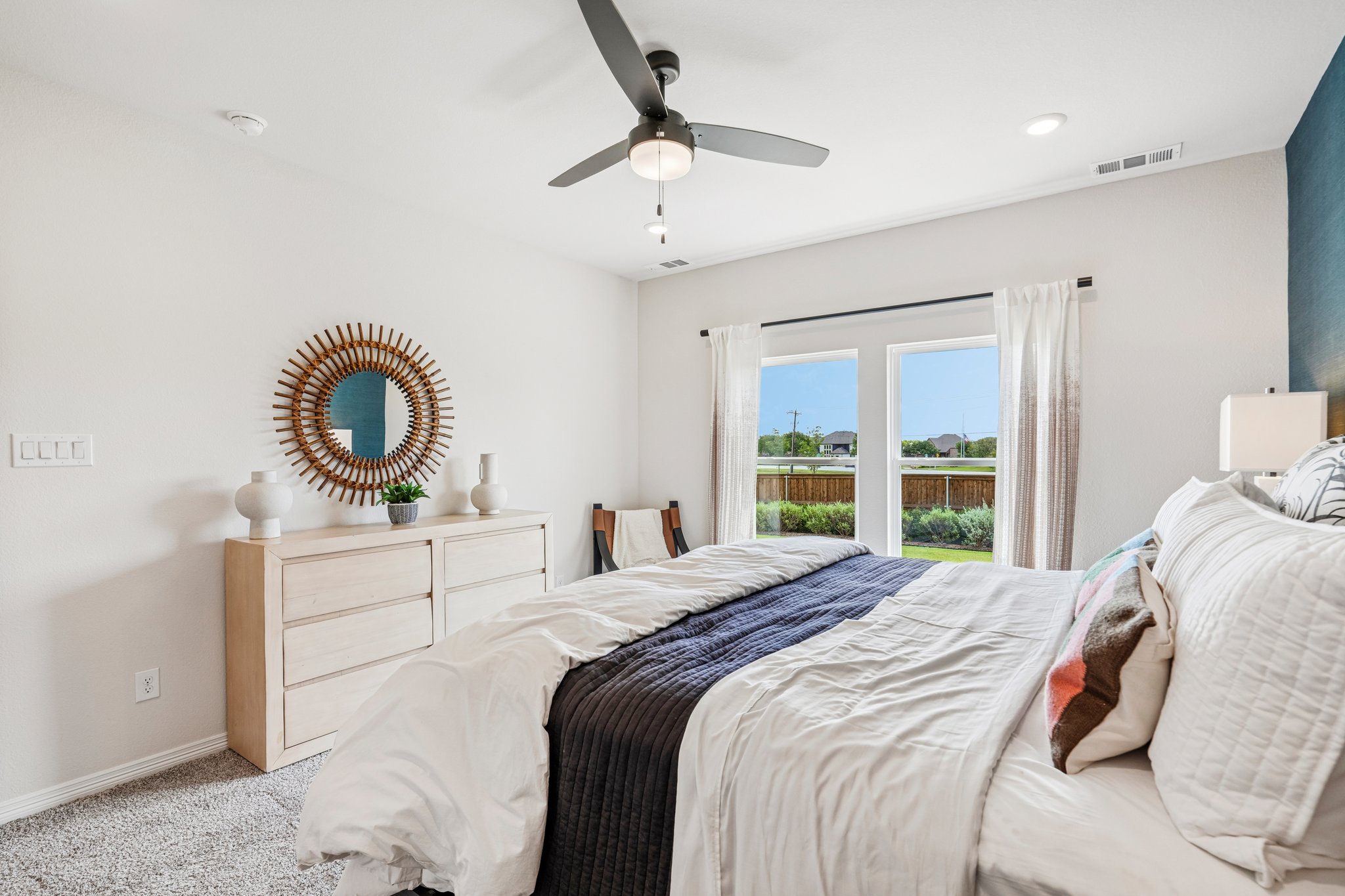 A bedroom with a large mirror and a bed.