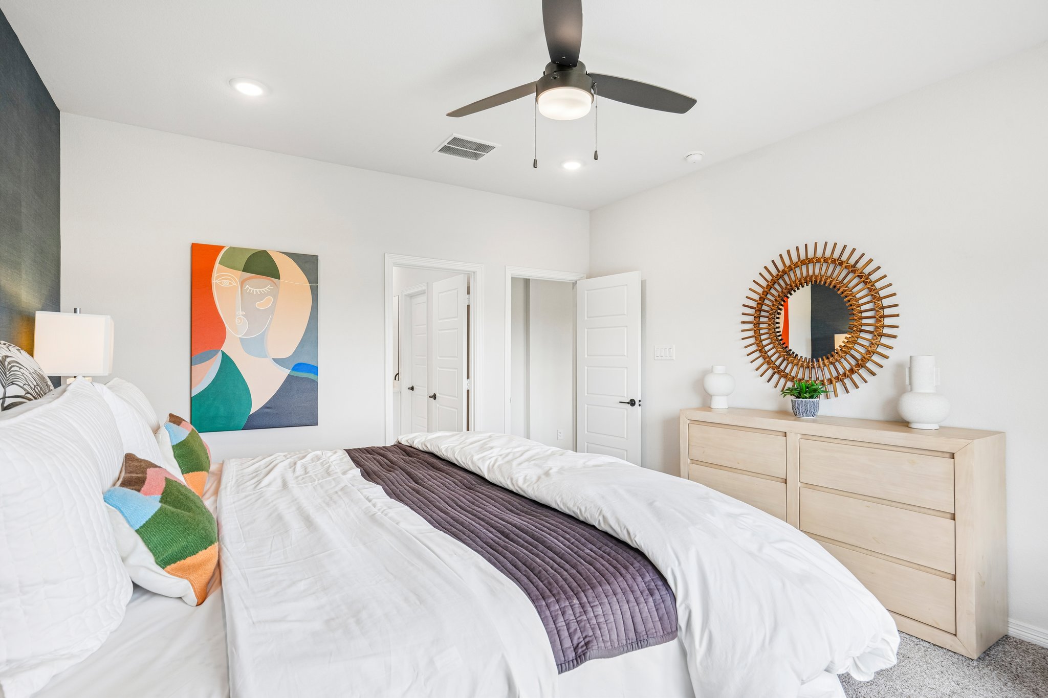 A bedroom with a bed and a mirror.